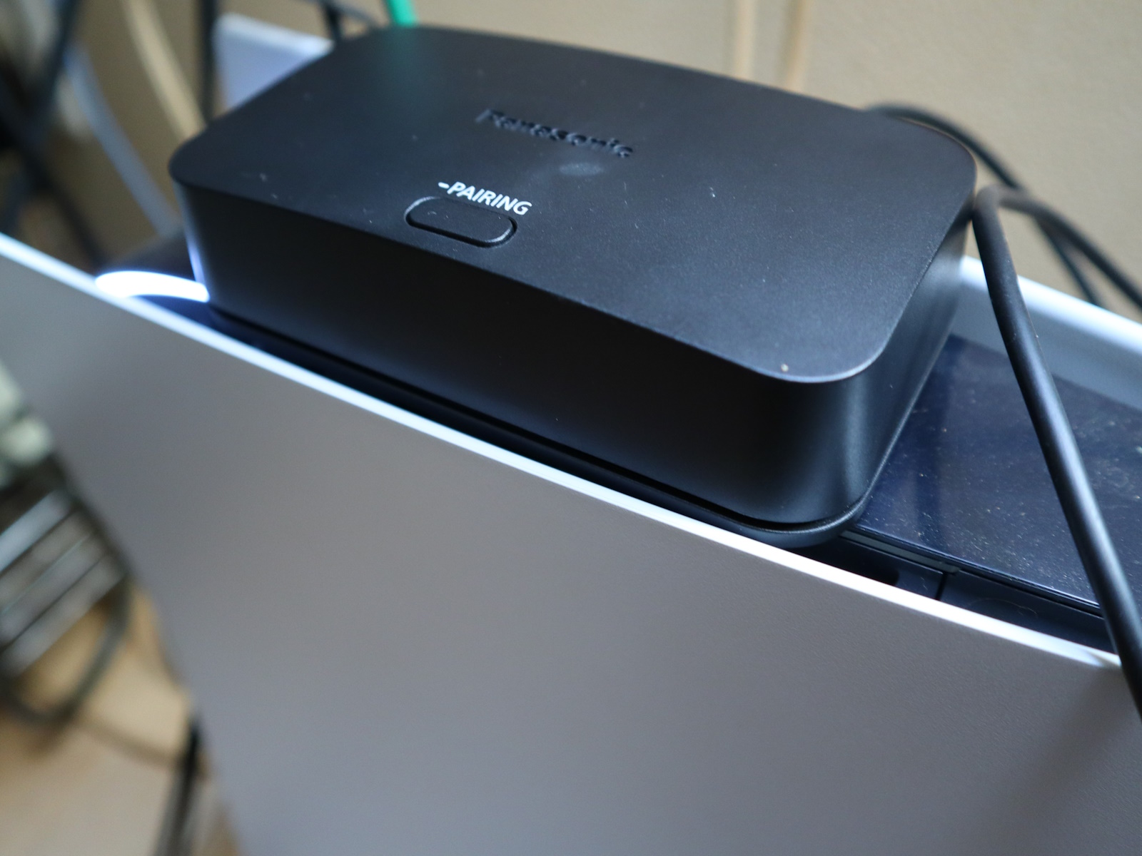 PS5と接続する際には前面ではなく、背面のUSB端子を使うのがオススメ。筆者宅のPS5は縦置きのため、天面部の上に無線ユニットを置いてみた