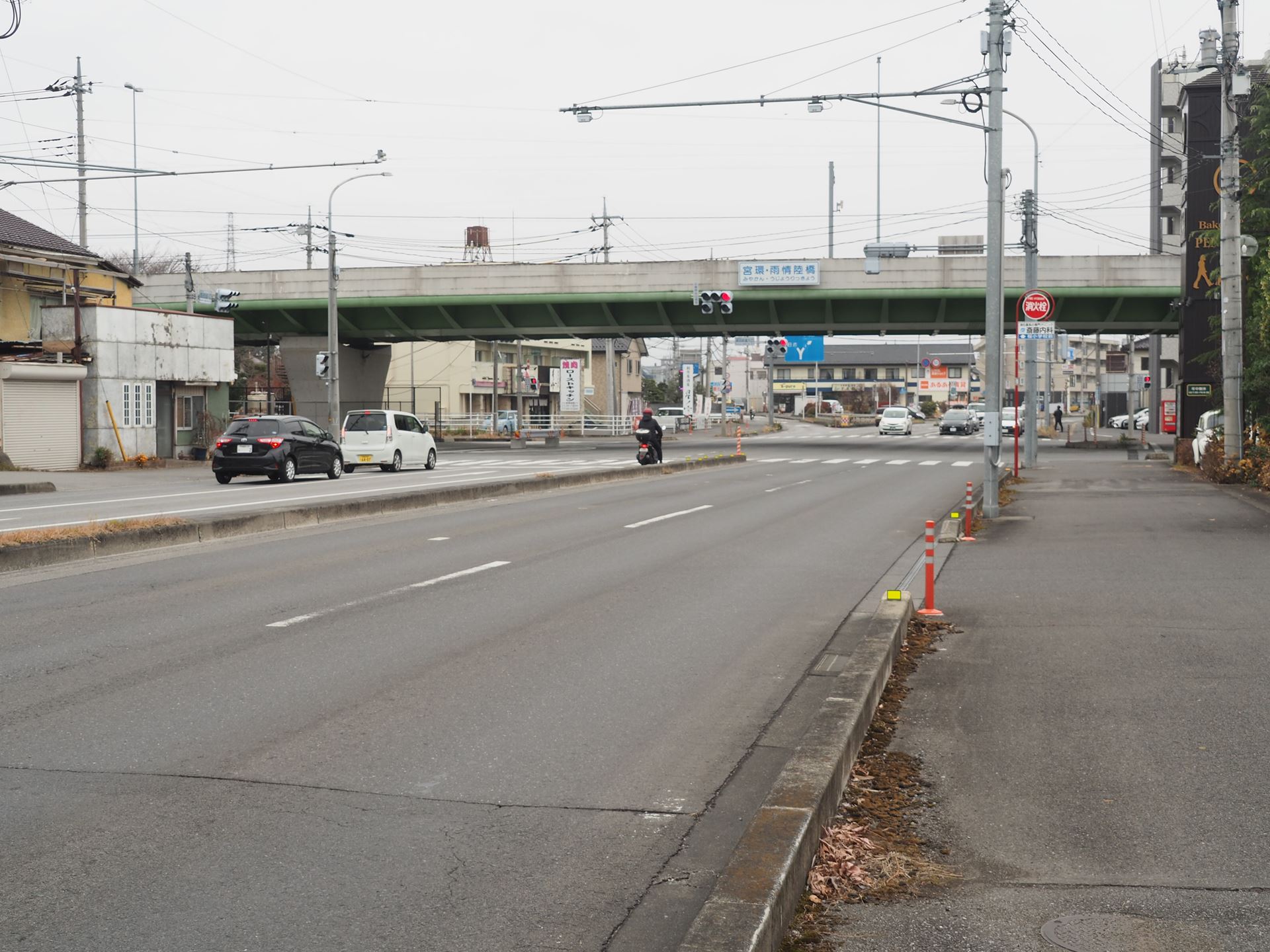 バス停から後ろを振り返ったところ。前に見えている高架の下をくぐって右折する