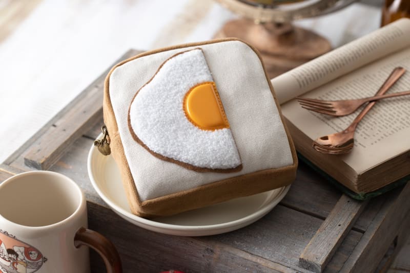 劇中に登場する、目玉焼きが乗ったパンを再現したポーチのリニューアル版。引手は青りんごをイメージしたチャームになっている。反対面はパズーとシータの織ネーム、内側には飛行石の織ネーム付き