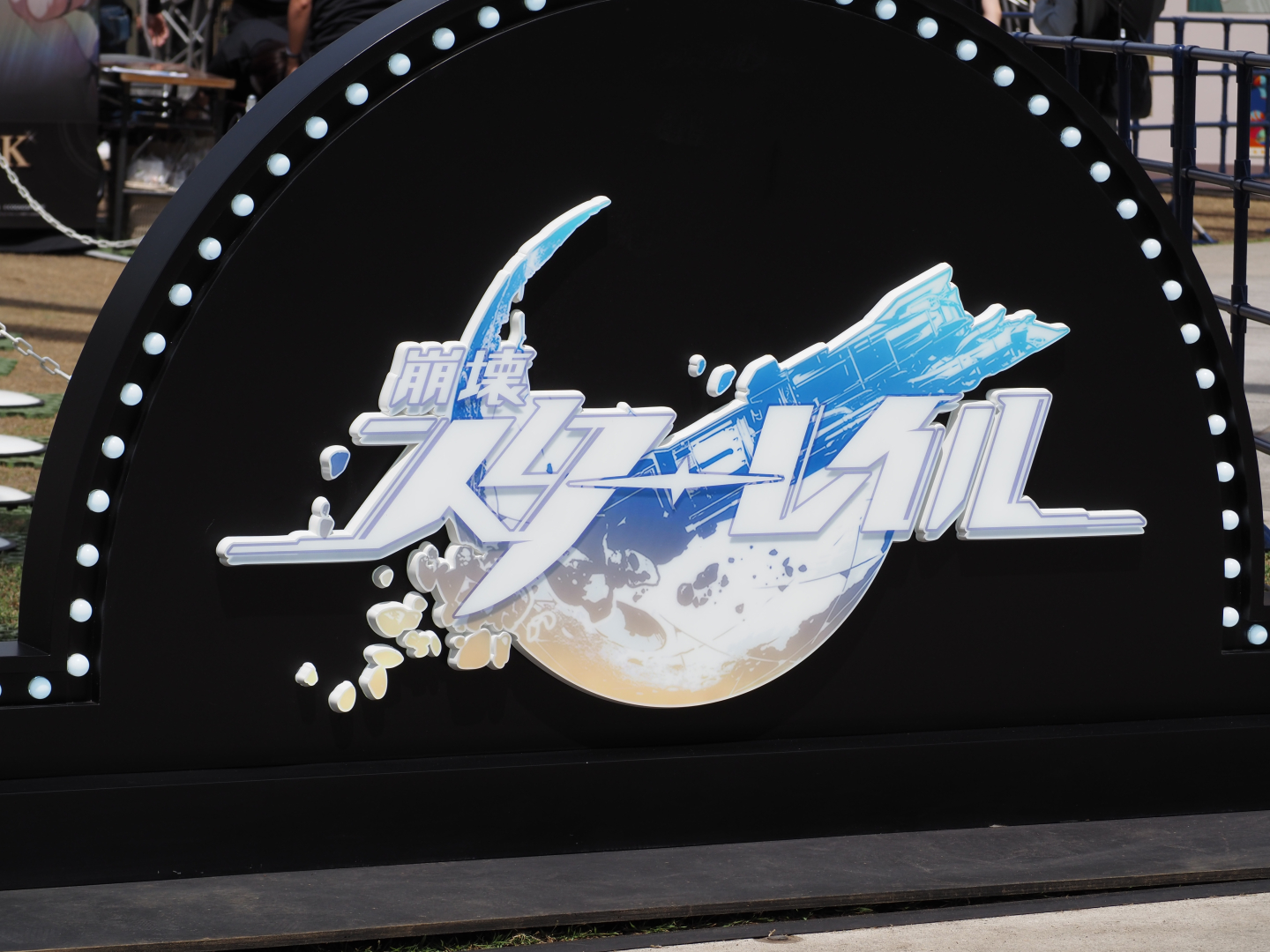 イベント会場にはわかりやすくゲームのタイトルロゴ。行き交う一般通行者たちも、つい立ち止まって撮影していた