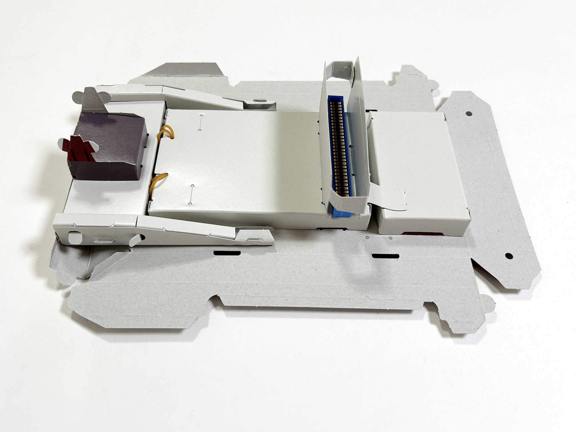 続いて基盤とハーネス、スライドレバーなどを取り付けてしまえば、裏面はほぼ完成となる。地味な部分ではあるが、ここをしっかり作っておくと後々見映えがよくなるというもの。カセットガイドは谷折りにして、白いつるつるの部分が内側に位置するようにする
