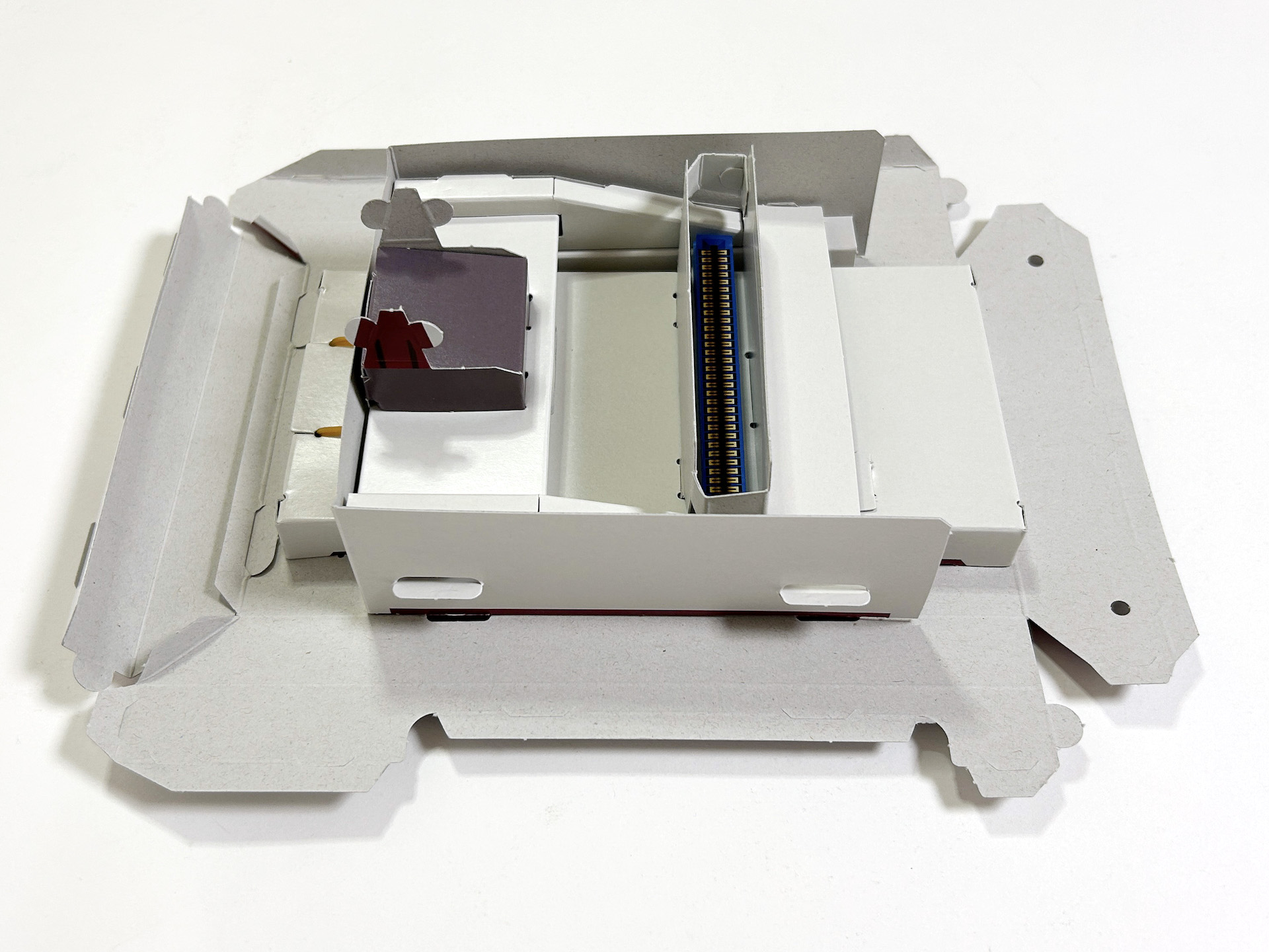 続いて基盤とハーネス、スライドレバーなどを取り付けてしまえば、裏面はほぼ完成となる。地味な部分ではあるが、ここをしっかり作っておくと後々見映えがよくなるというもの。カセットガイドは谷折りにして、白いつるつるの部分が内側に位置するようにする