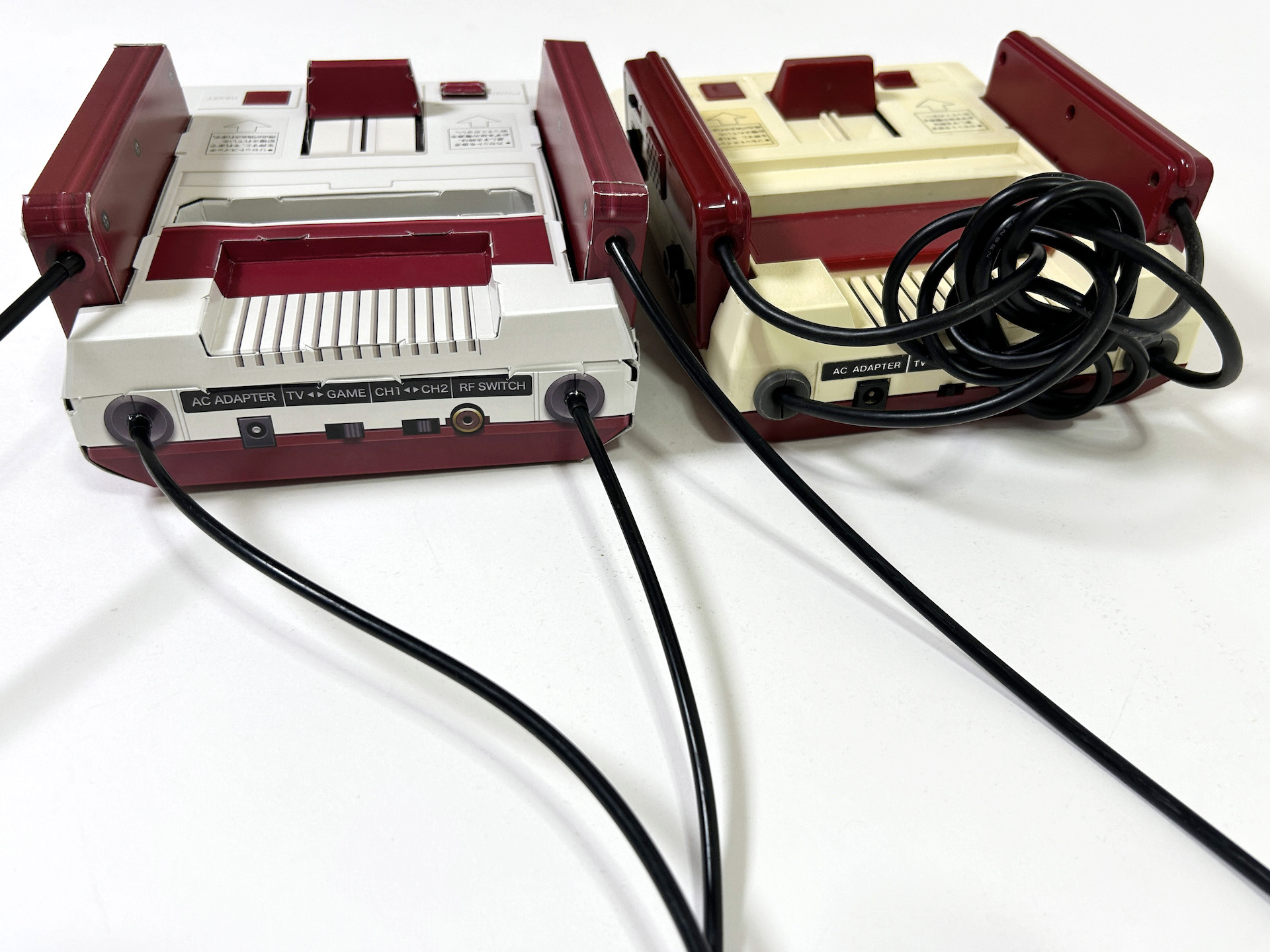 隣に、実機ファミリーコンピュータを配置して撮影してみた。ペーパークラフトはつなぎ目部分が見えてしまうものの、遠目からであればなかなかオリジナルに近いクオリティに仕上がっている。実機は経年で黄ばんでしまうが、ペーパークラフトであればそうなることもないのも利点、かもしれない