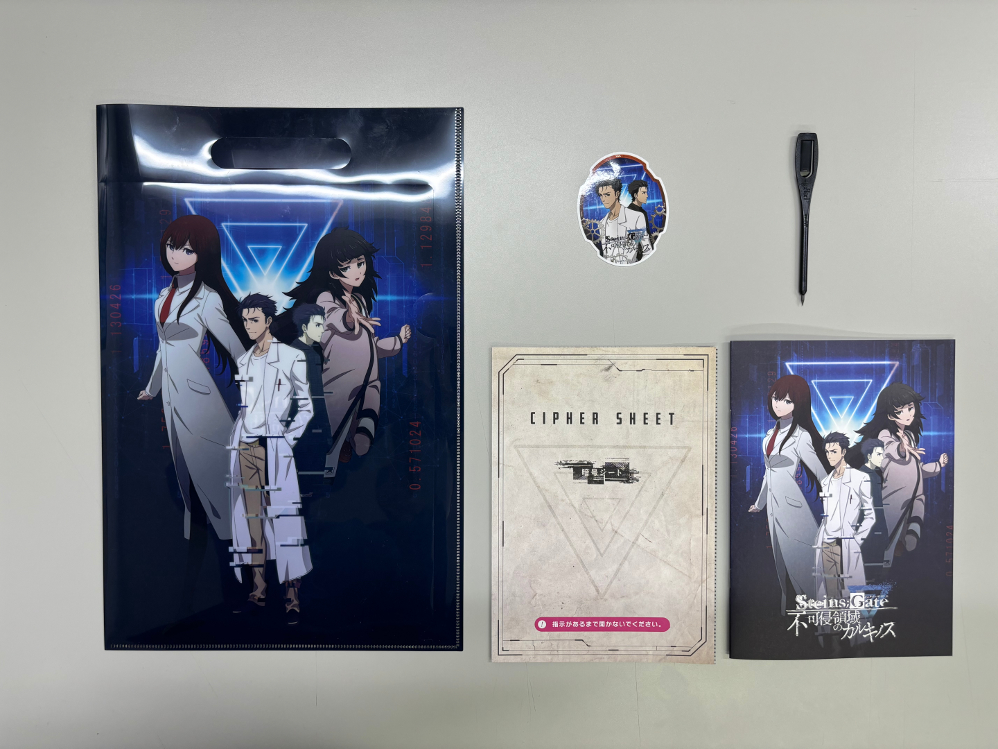 謎解きキット（スタンダードセット）の同梱物一式。シールは3種類からランダムで今回はオカリンだった