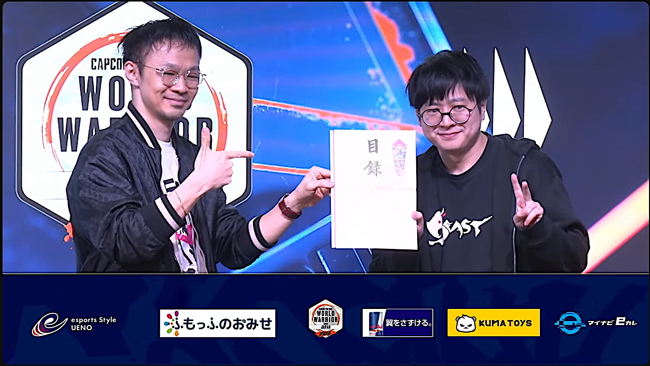 配信より。ハメコ。氏から受け取った目録を片手にポーズを決めるふ～ど選手