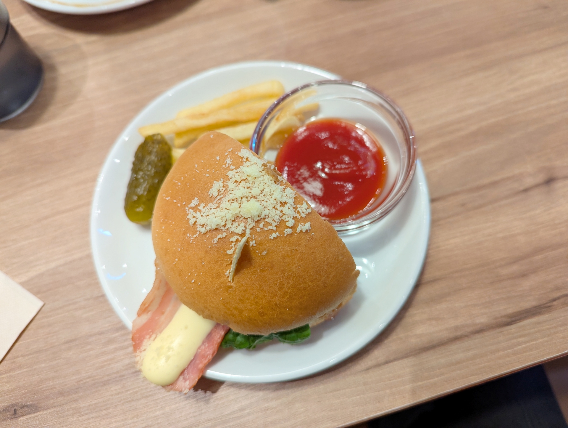 「オトモアイルーのハンバーガープレート」の試食バージョン。半分に切られているが、アイルーの耳のトルティーヤはちゃんと突き刺さっていた。ポテトやピクルスも含めて、大変おいしゅうございました