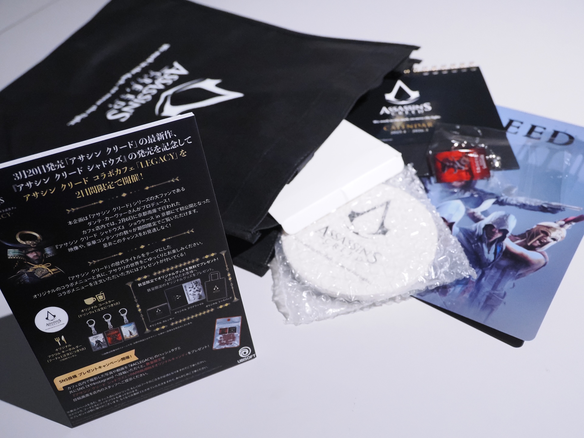 フード×1注文につきアクリルキーホルダーが1点、ドリンク×1注文につきオリジナルコースターが1点もらえる。また、カフェに入店した人へカレンダー、クリアファイル、トートバッグといったオリジナルグッズが数量限定でプレゼントされる。こちらもぜひゲットしていただきつつ、「アサクリ」世界にどっぷり浸ってほしい