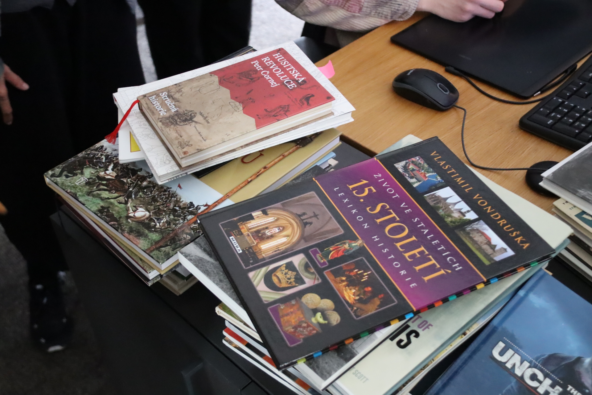 オフィス内、アートチームの席に山積みされた資料と開発中の場面。現地調査を含め念入りに行なっているという