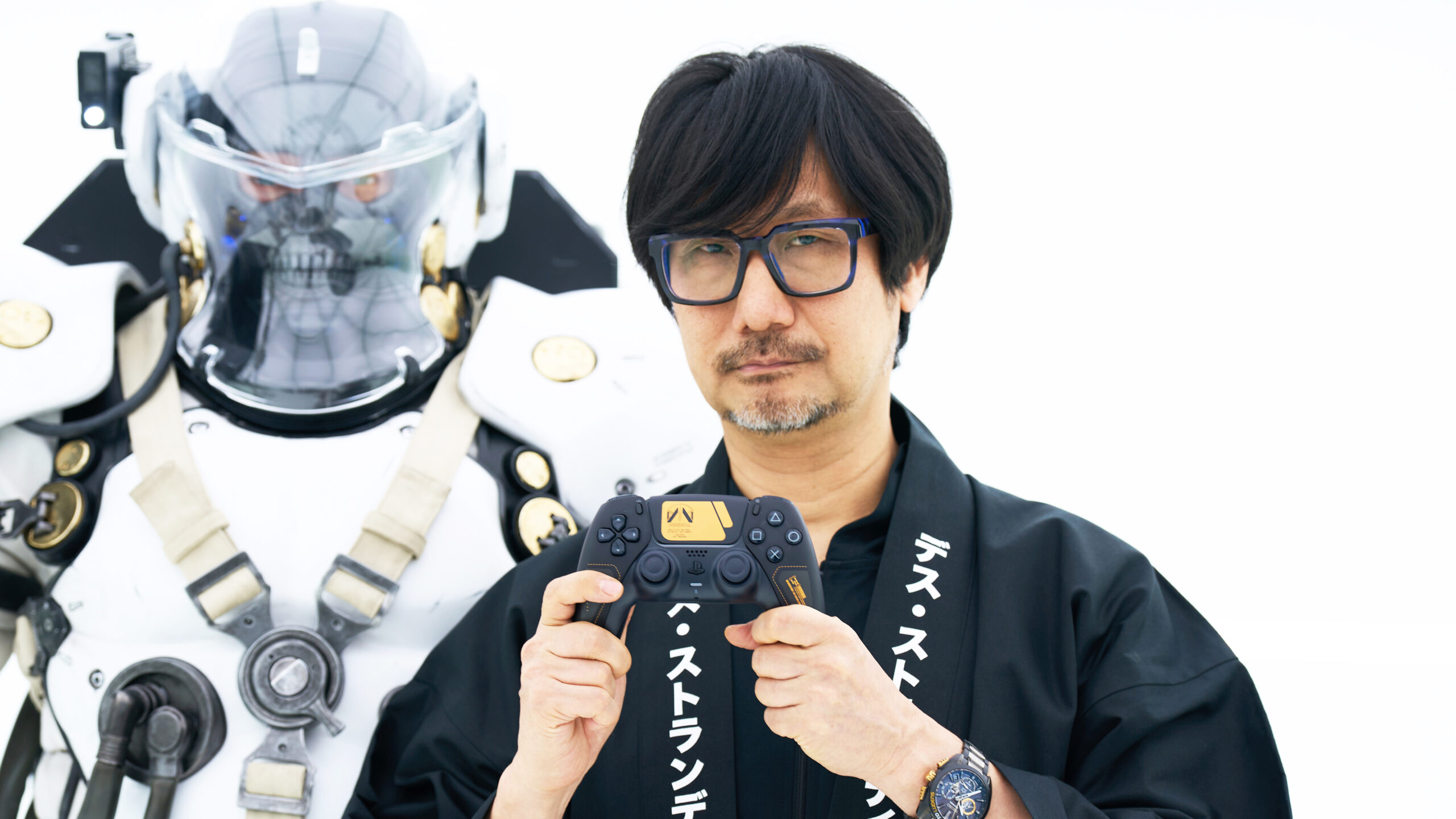 「DEATH STRANDING 2: ON THE BEACH」のイベントでコントローラーを紹介する小島秀夫監督