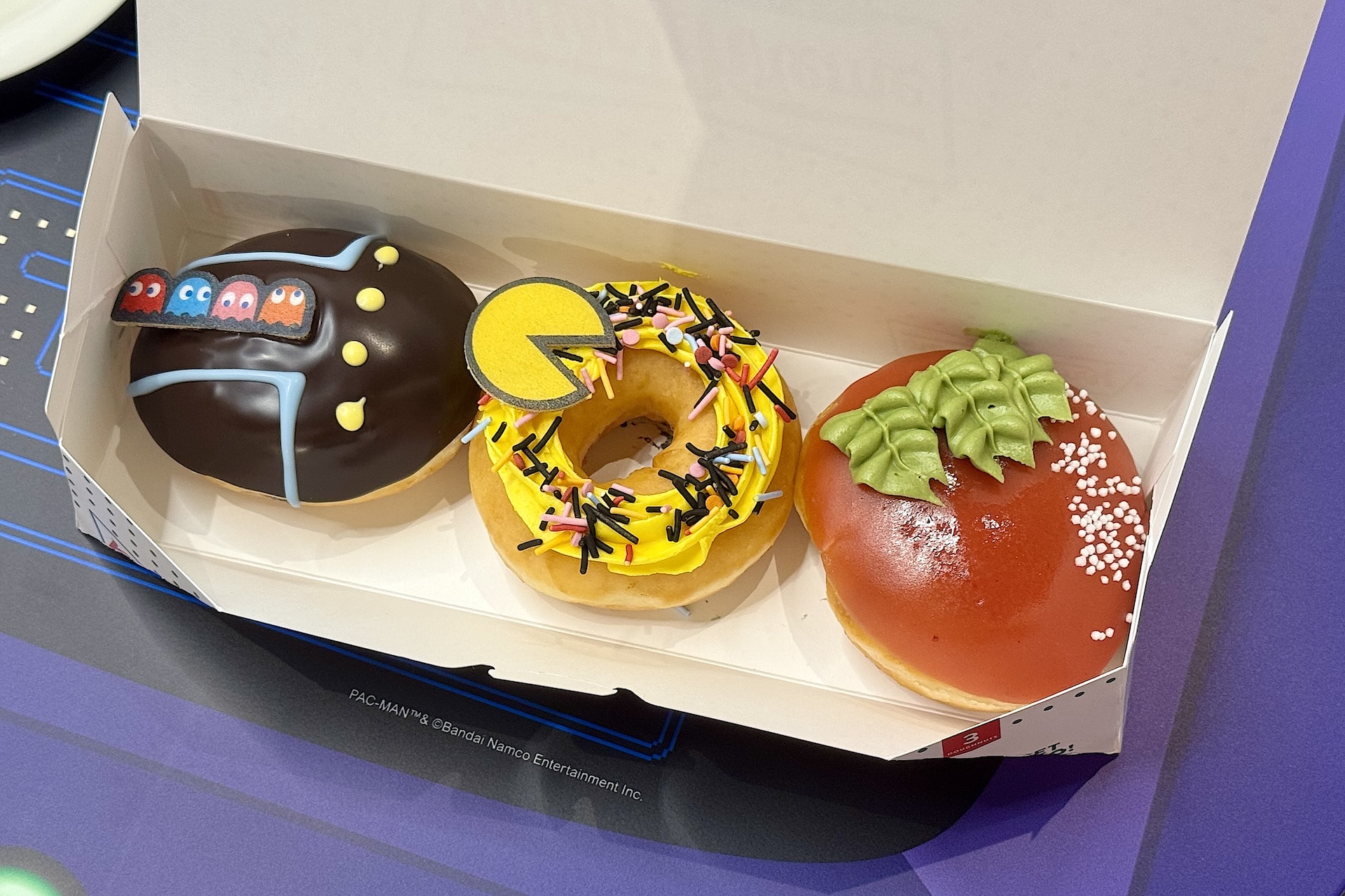 左から「ゴースト チョコレート」410円（イートイン418円）、「パックマン カスタード スプリンクル」410円（イートイン418円）、「パワー ストロベリー」388円（イートイン396円）。3個入りのボックス「パックマン ボックス（3個）」1,177円（イートイン1,199円）も用意される