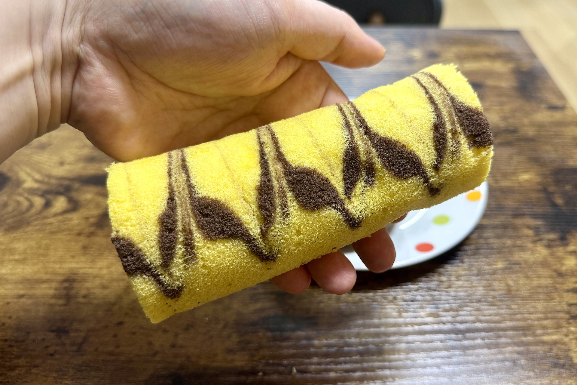 「チャーリー・ブラウン チョコバナナロールケーキ」は手に持ってみるとその大きさがおわかりいただけるかと思う。重さもずっしり！