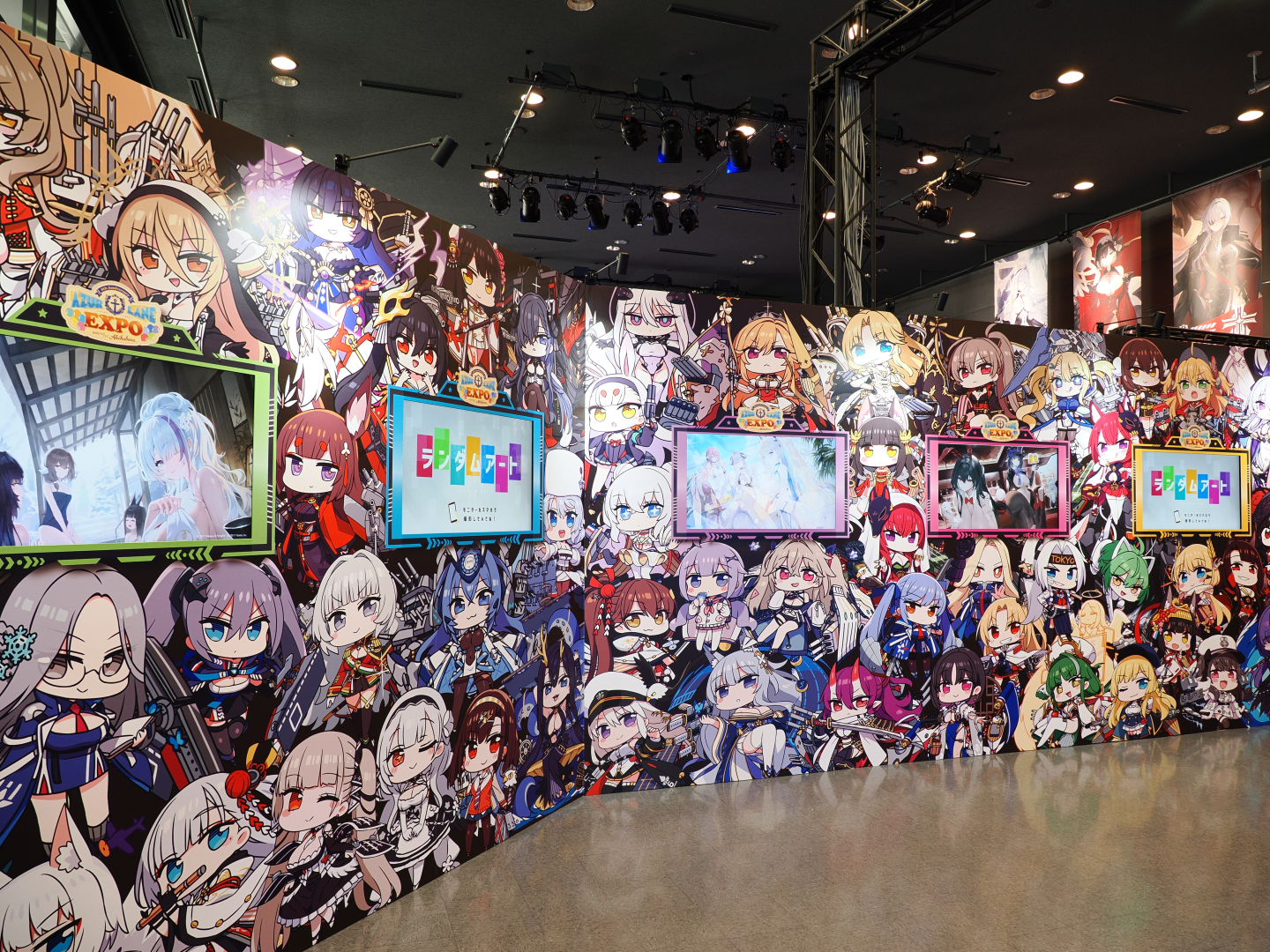 「ランダムアート」。イラストが高速で入れ変わる映像がモニターに映し出されておりスマートフォン撮影して楽しむ