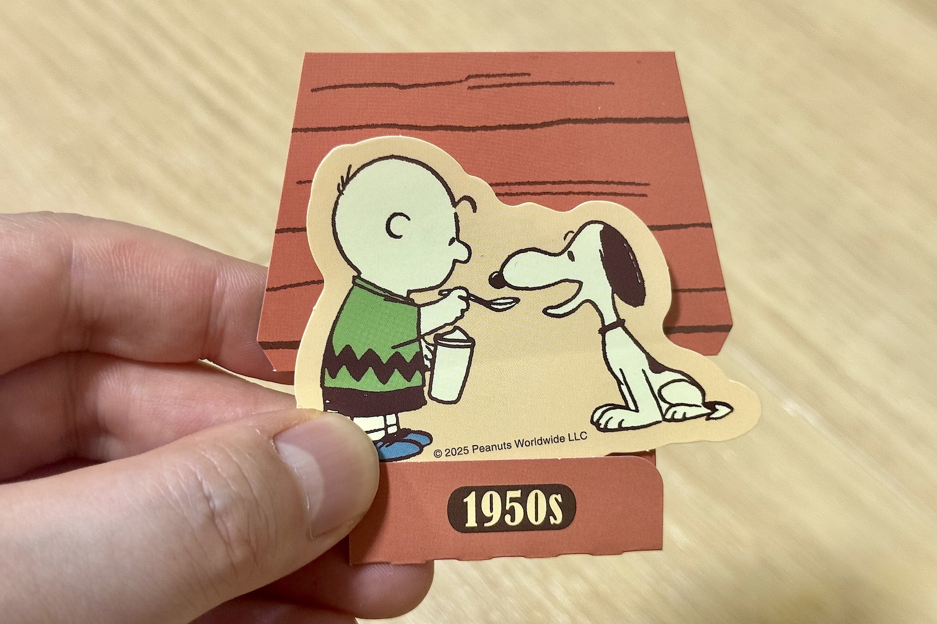 ステッカーと組み立てて自立させることができる犬小屋モチーフの台紙がセットになっている