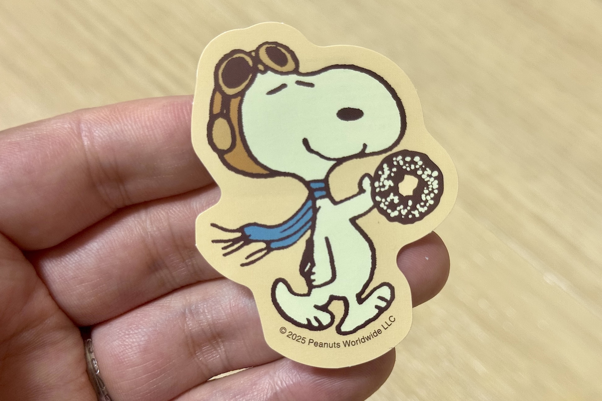 手に持っているドーナツは販売されている商品「スヌーピー チョコケーキドーナツ」だろうか