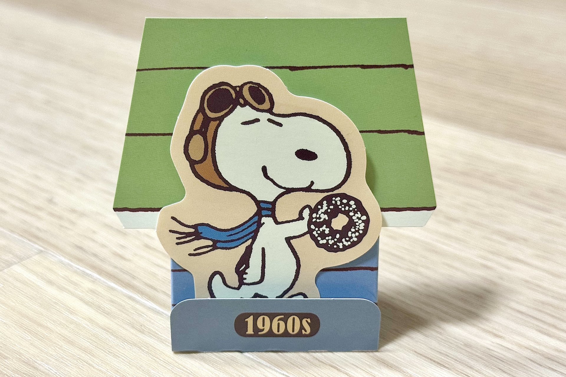 手に持っているドーナツは販売されている商品「スヌーピー チョコケーキドーナツ」だろうか