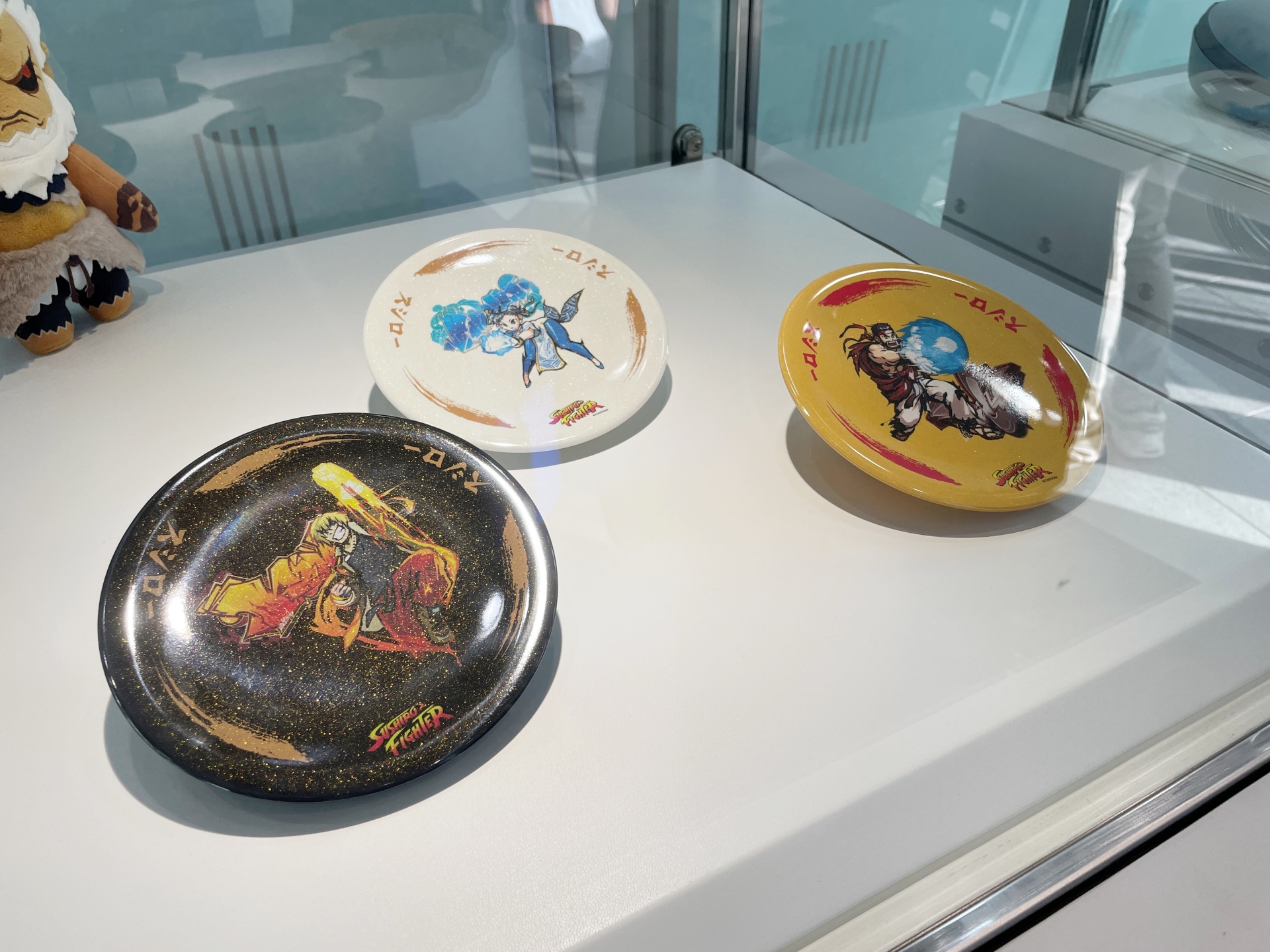 「マジック・ザ・ギャザリング」のマーベルコラボや、「ストリートファイター6」とスシローコラボのアイテムが展示されている