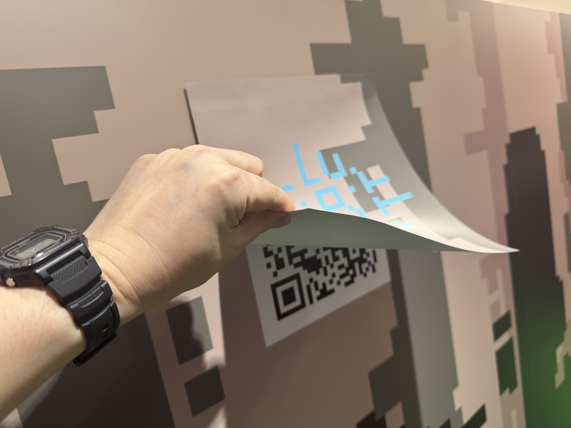 壁の一部がめくれるようになっていて、その下には何やらQRコードが!?