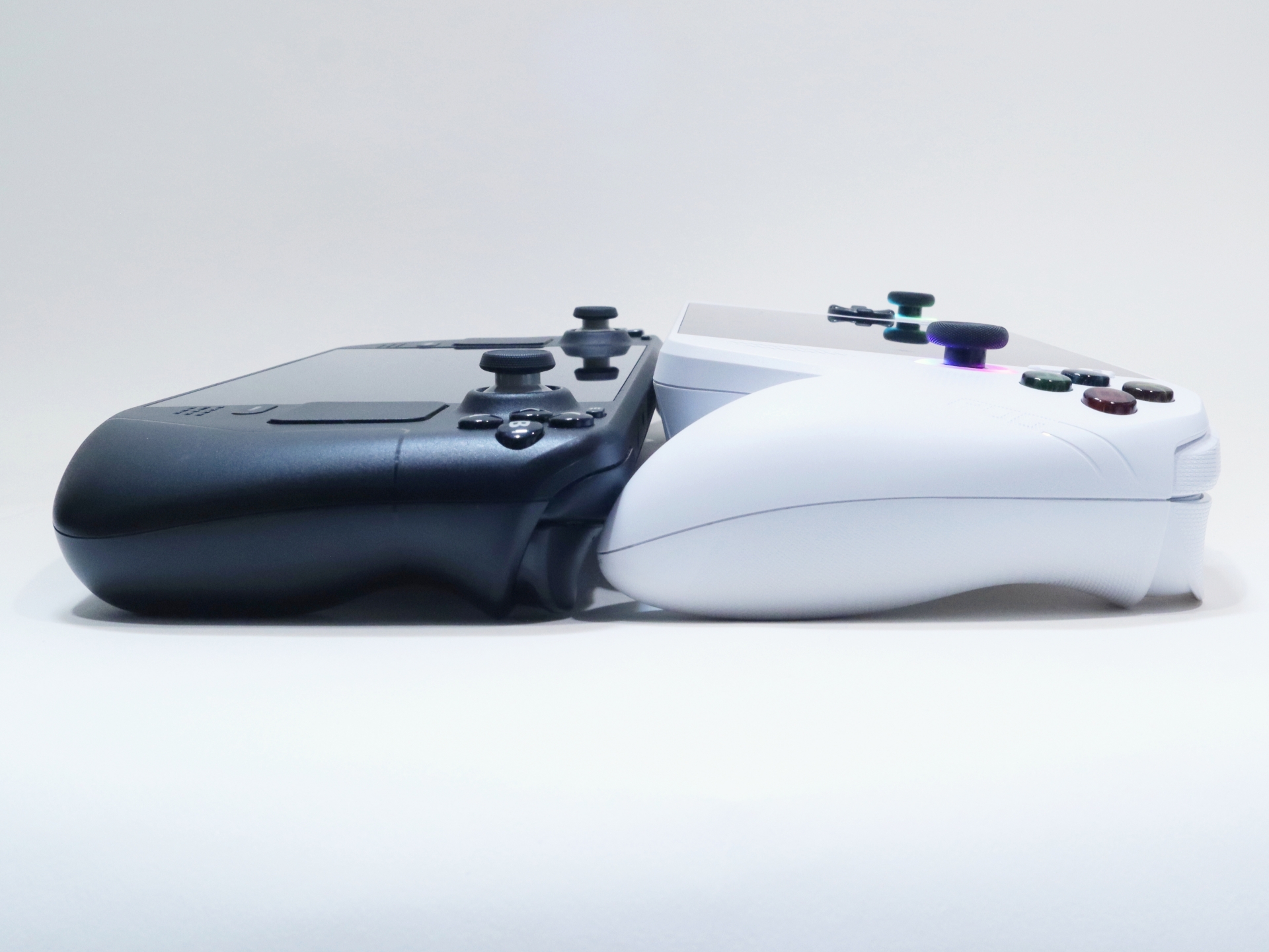 「Steam Deck」（左）と並べたところ。「ROG Xbox Ally」（右）はグリップの形状がかなり突出しているため、並べて置いてみると本体が前傾姿勢となり、本体部がかなり浮いているのが分かる