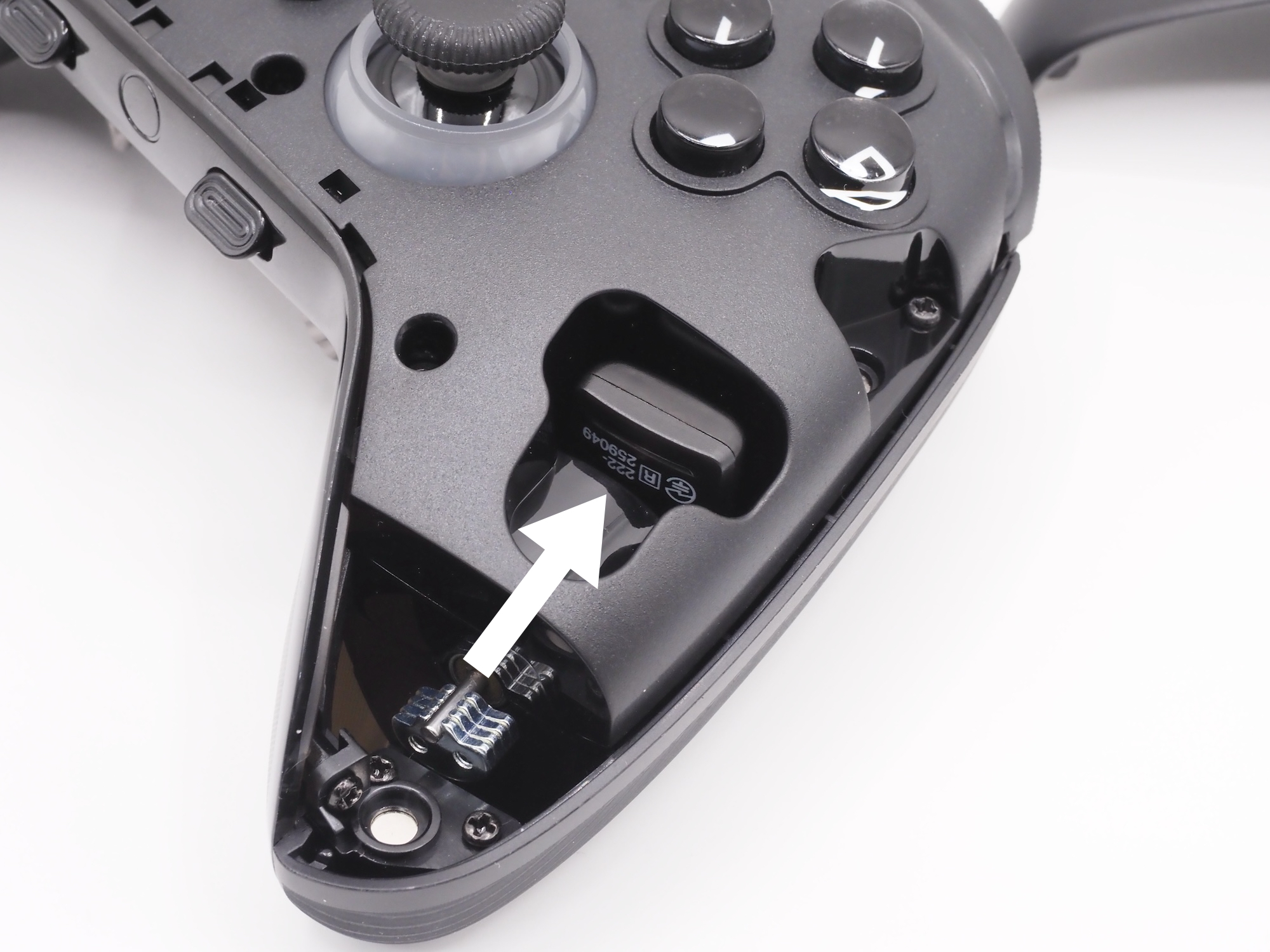 USBレシーバーは筐体内に収納可能。右グリップ側（画像中央の矢印で示した場所）に差し込む形だ