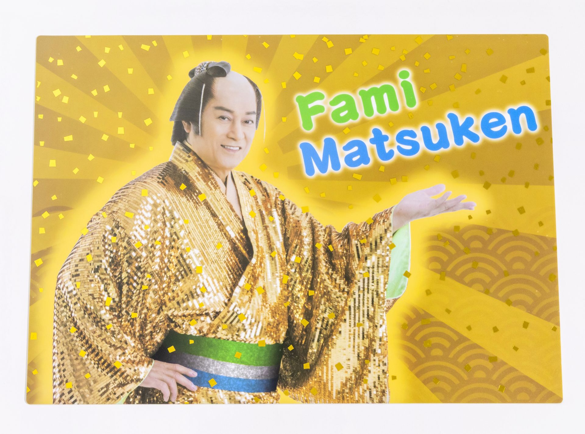 鮮やかなゴールドカラーの背景に、マツケンの笑顔が輝くデザインのランチョンマット。毎日の食事の時間をより楽しく、いつもの食事を華やかに演出