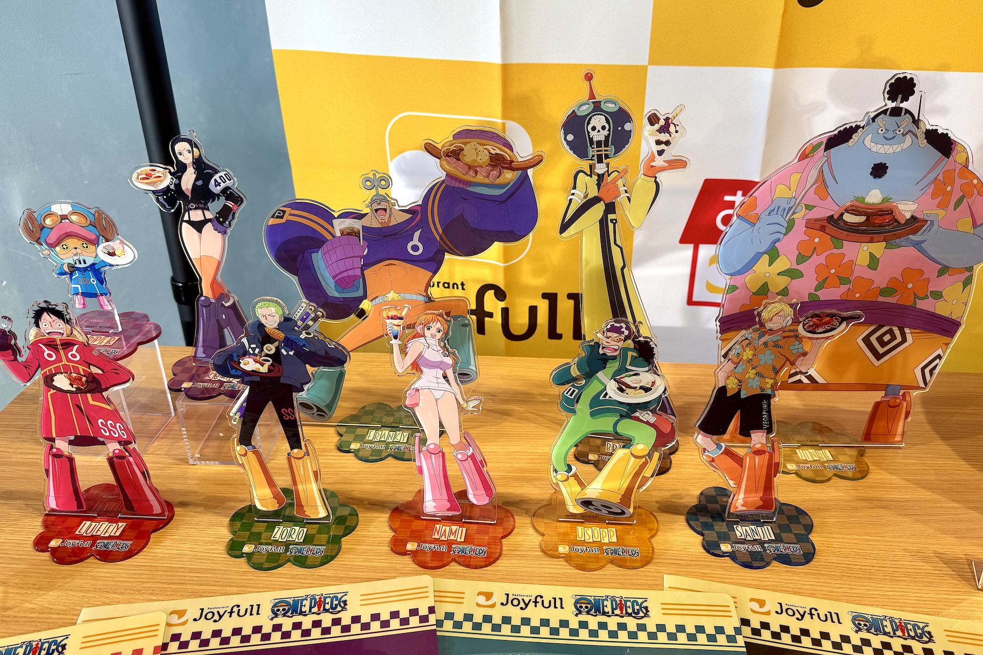 アクリルスタンド 全10種（サイズ：人物 約H300mm×W150mm、台座 約H80mm×W80mm）。コラボメニュー3,000円以上のレシートで応募可能