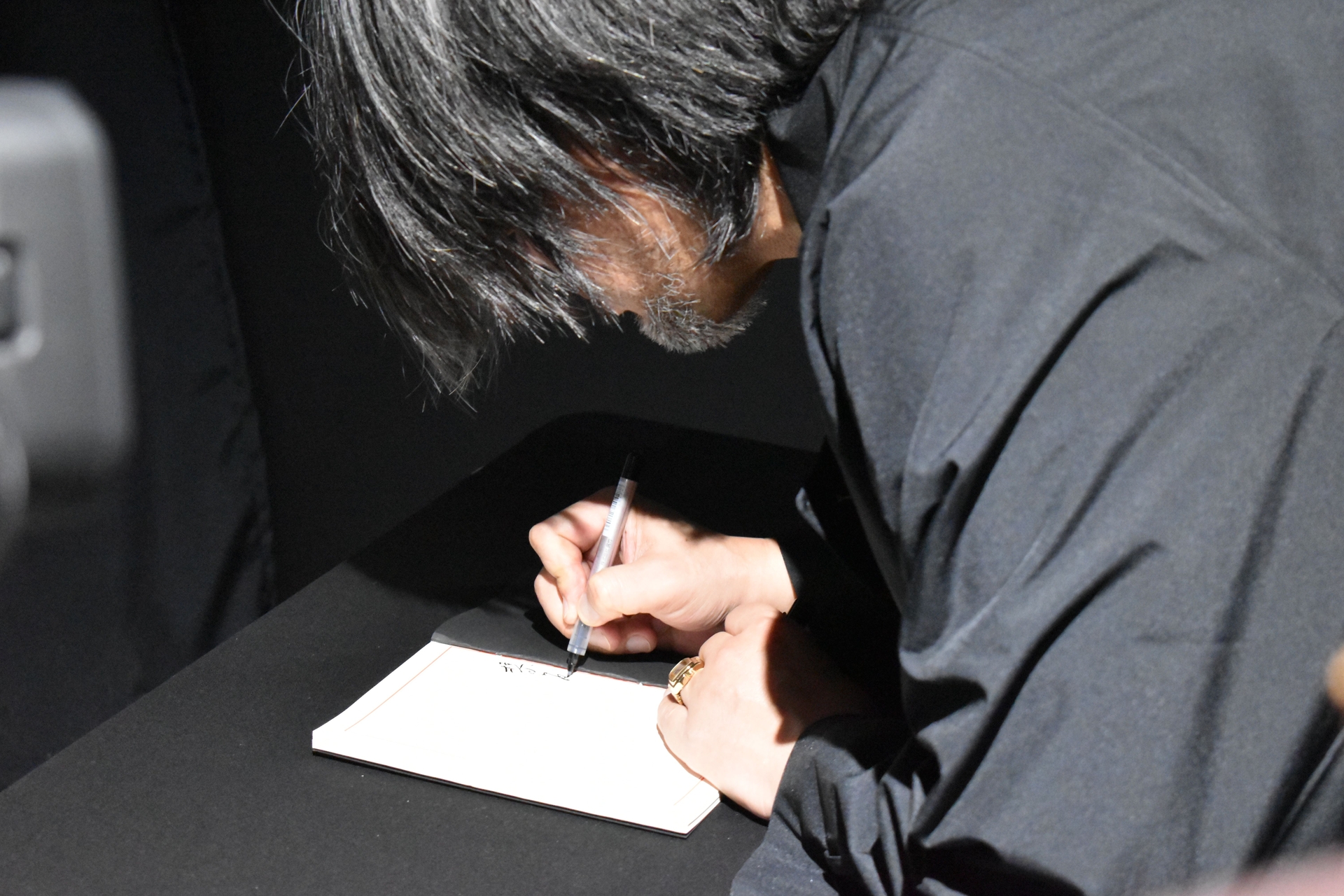 「葬」のエリアでは錦山の遺影が。横山氏も記帳し、献花を行った。もちろん、会場を訪れる参加者も体験できる