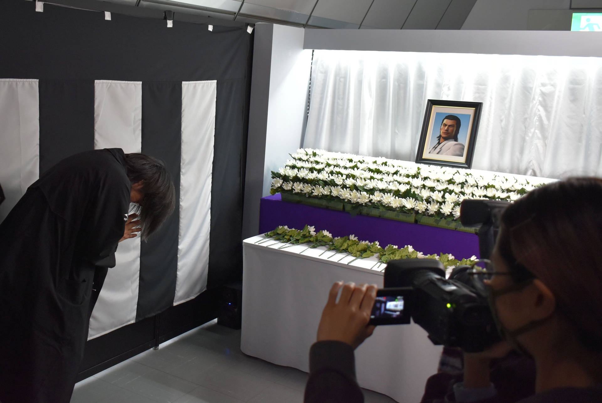 「葬」のエリアでは錦山の遺影が。横山氏も記帳し、献花を行った。もちろん、会場を訪れる参加者も体験できる