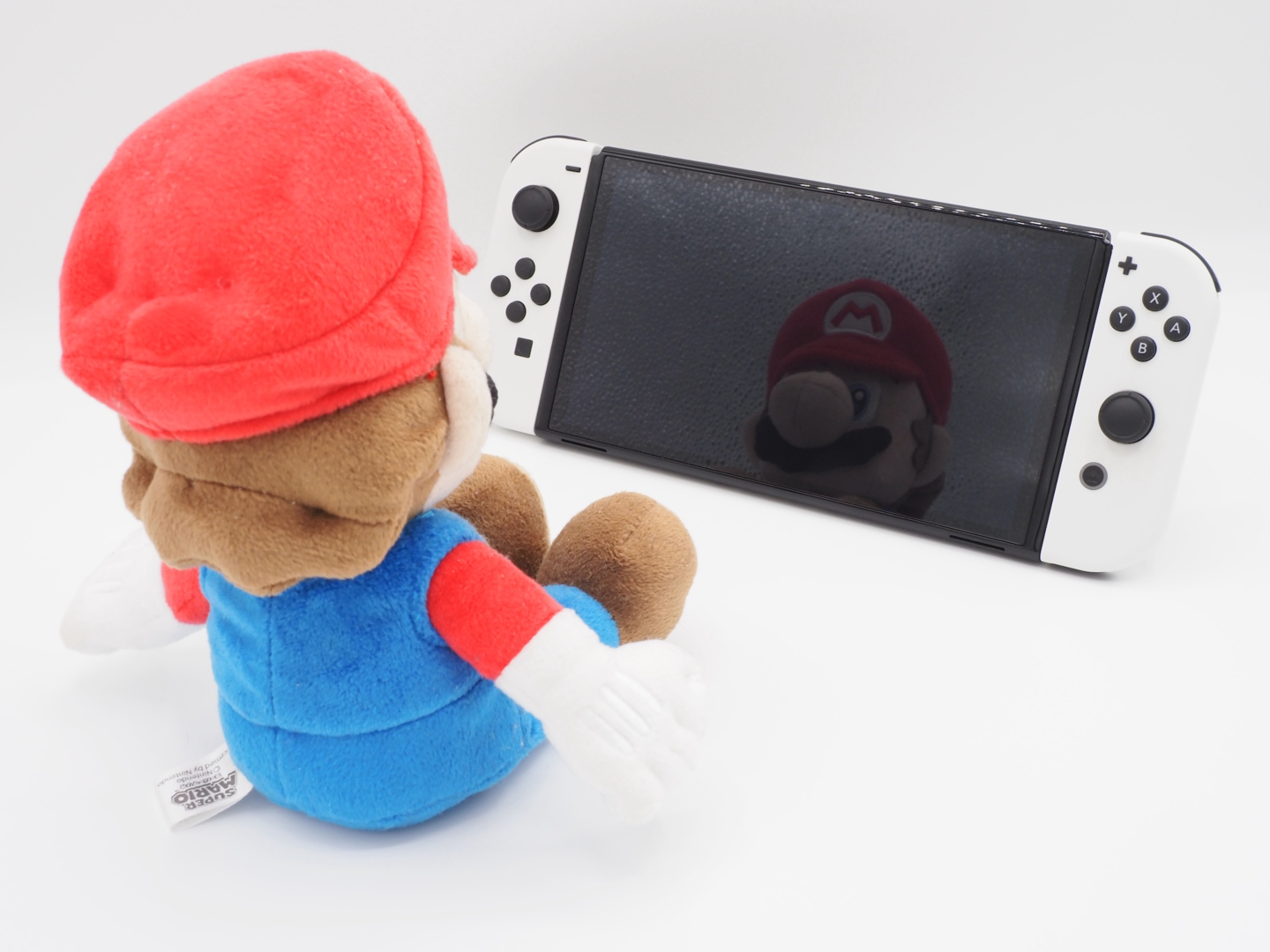 参考までに、こちらは純正のグレアフィルムを貼ったSwitch（有機ELモデル）。マリオの顔がガッツリ写りこんでいます