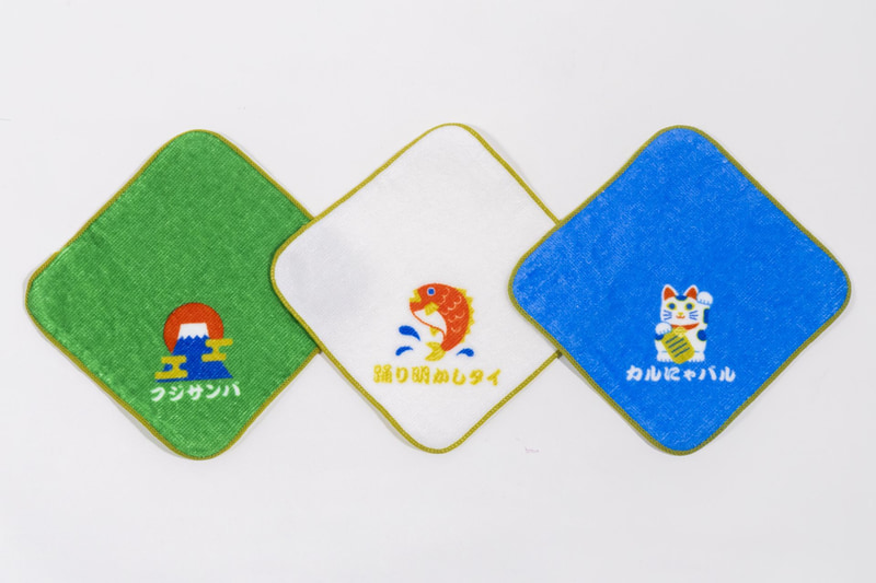 「マツケンサンバII」の歌詞に合わせて「フジサンバ」、「踊り明かしタイ」、「カルにゃバル」がデザインされた福々しいハンドタオル。全3種から好きなデザインを選べる