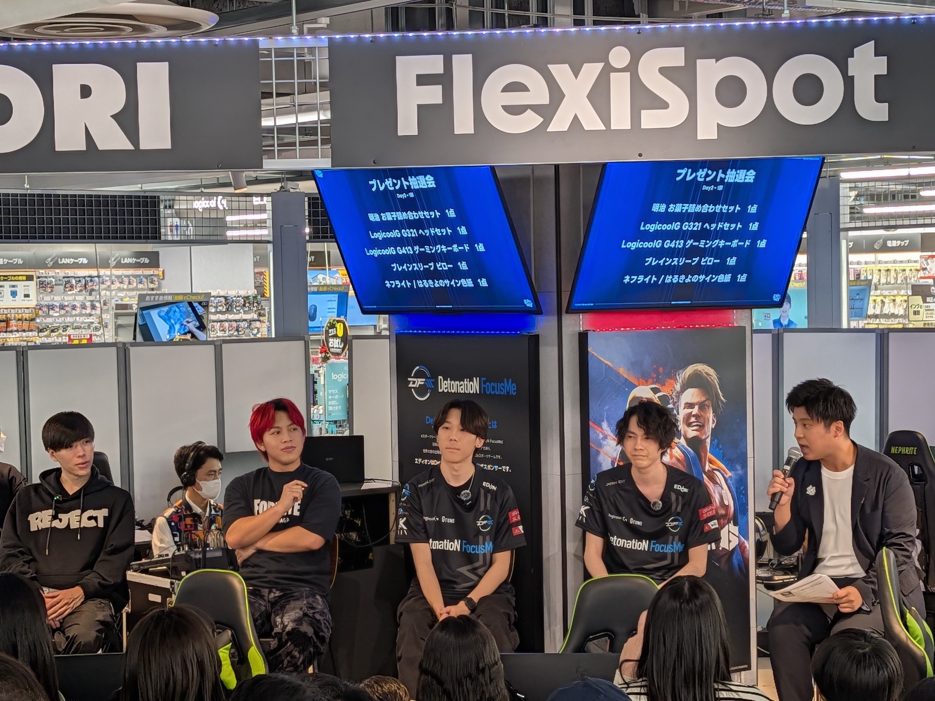 2日目の第1部はDFM所属ネフライトさん、ストリーマーのHarukiyoさん、REJECT所属くらら選手、QTDIG無限大(∞)所属LiaqN選手が集まり、「フォートナイト」対戦が行なわれた。MCはトンピ？氏。年齢層は比較的若めで、子供たちの姿もちらほらと見かけた