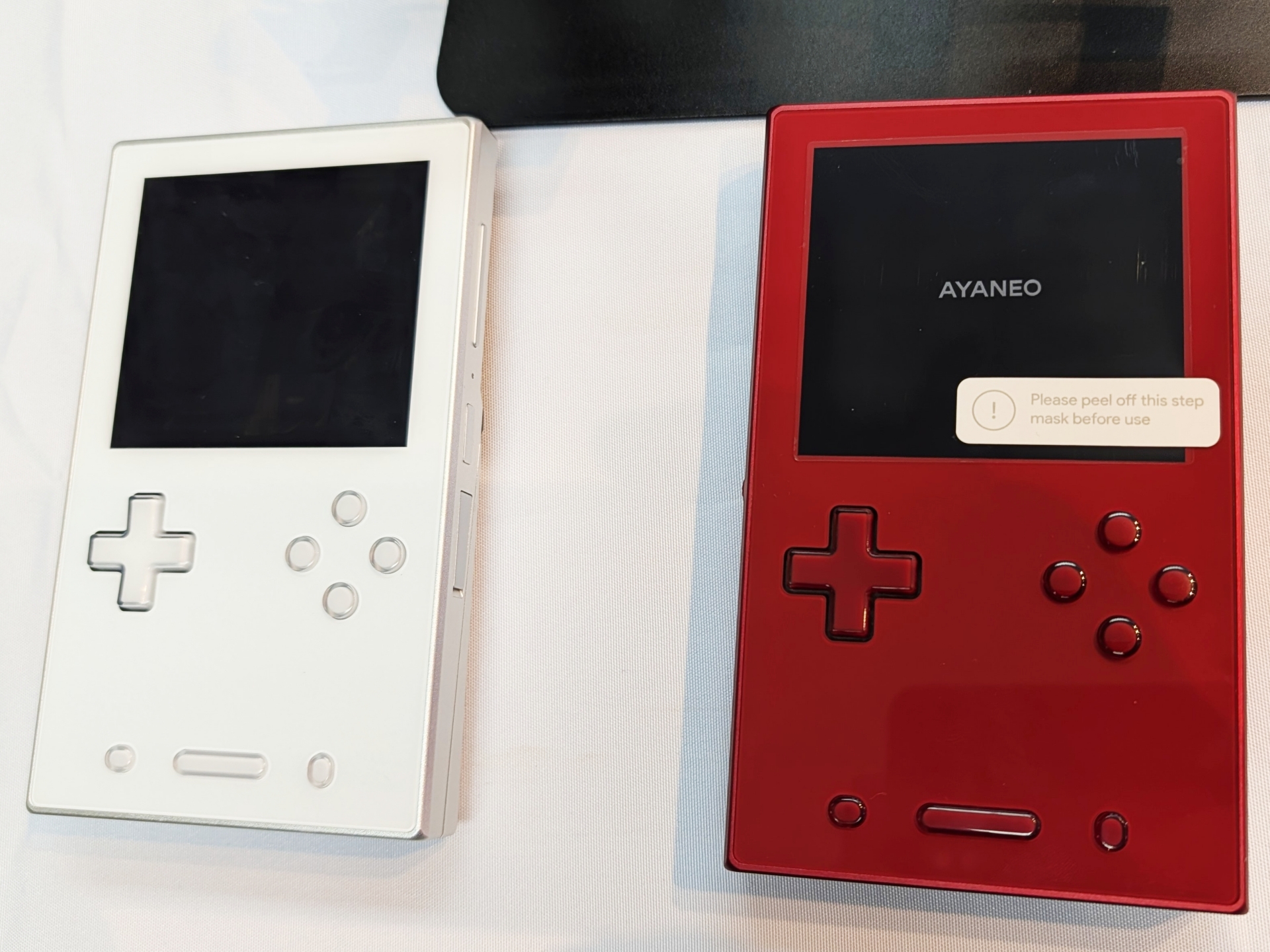 レトロゲーム機デザインの小型ゲーミングデバイス「AYANEO POCKET VERT」。本体カラーはムーンホワイト、ミッドナイトブラック、ラヴァレッドの3色展開だが、会場にはムーンホワイトとラヴァレッドが展示されていた
