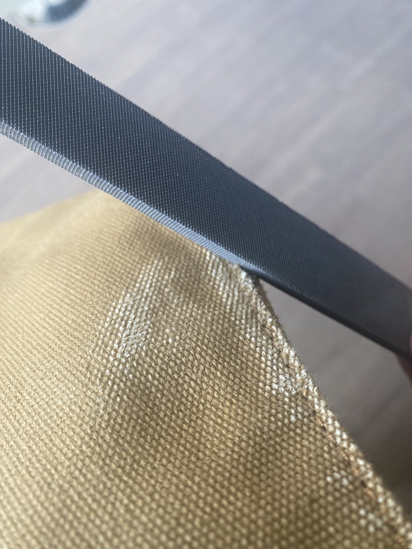 帆布は硬いので、ヤスリの角を立てて使うとボロボロにしやすい