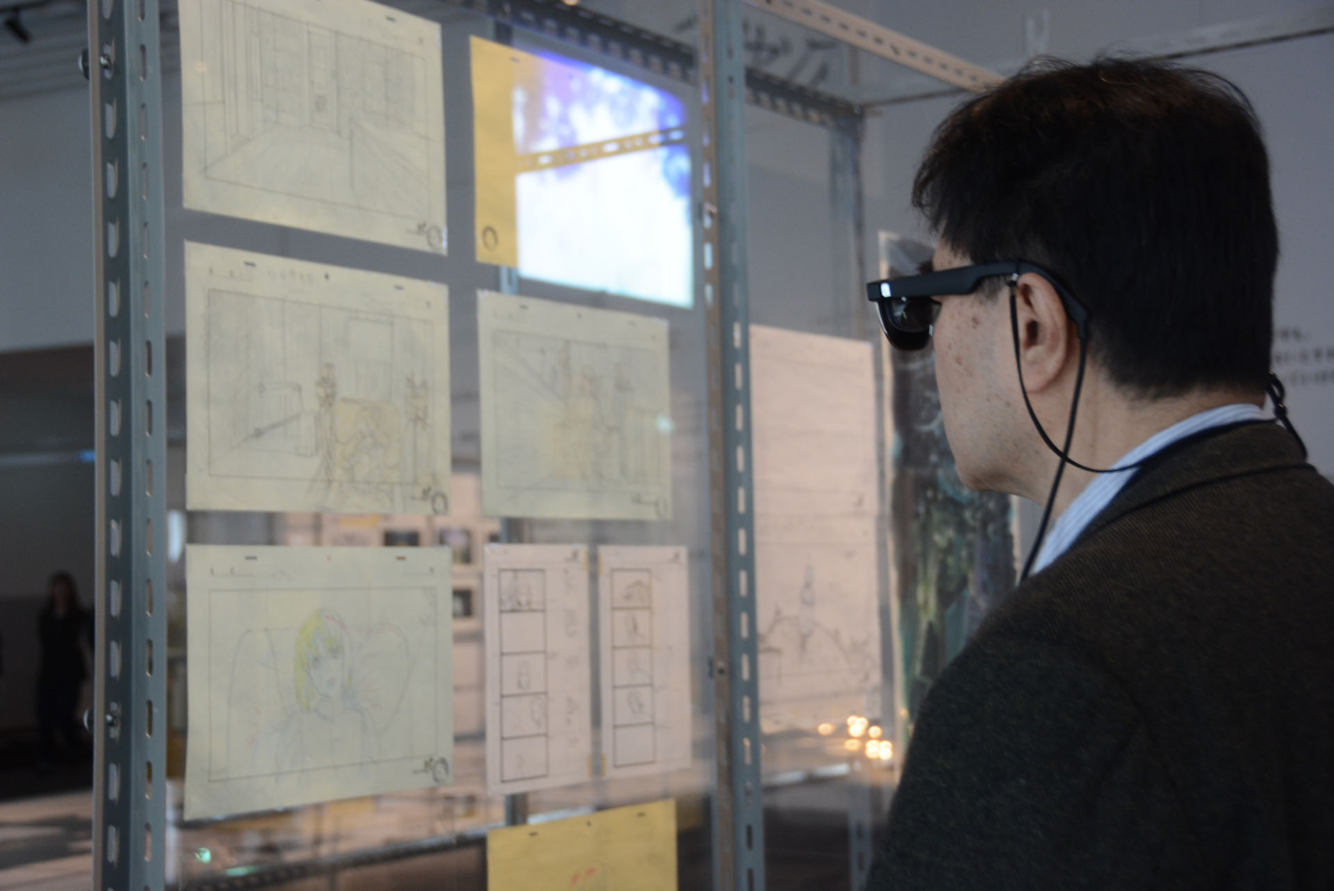 サングラス型のARグラスをかけるとさらに多彩な情報を入手できる。原画をキーに、実際のアニメーションとその背景が解説されるのだ