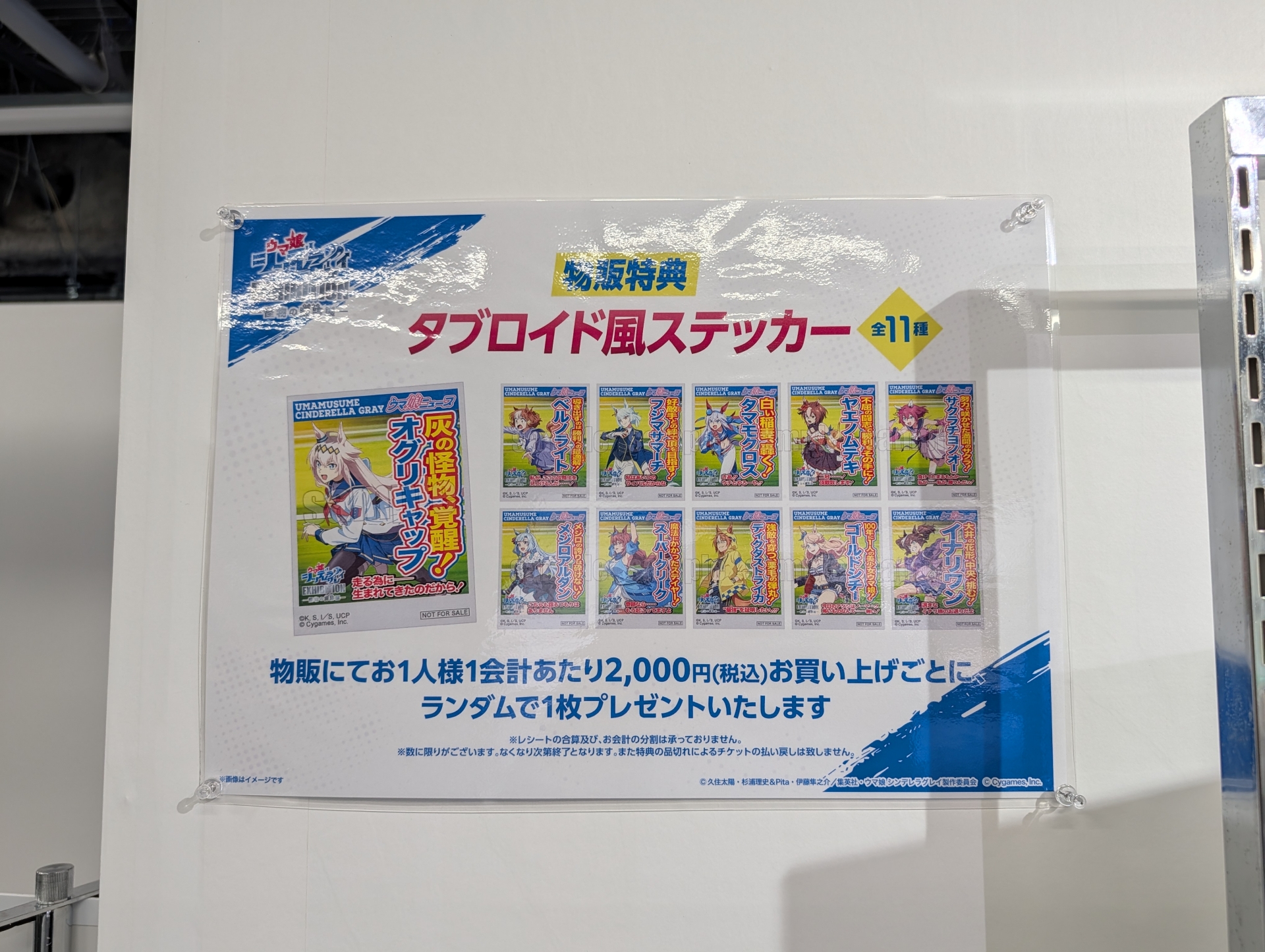 物販での購入特典として、2,000円お買い上げごとに全11種類のタブロイド風ステッカーの中からランダムで1枚がプレゼントされる