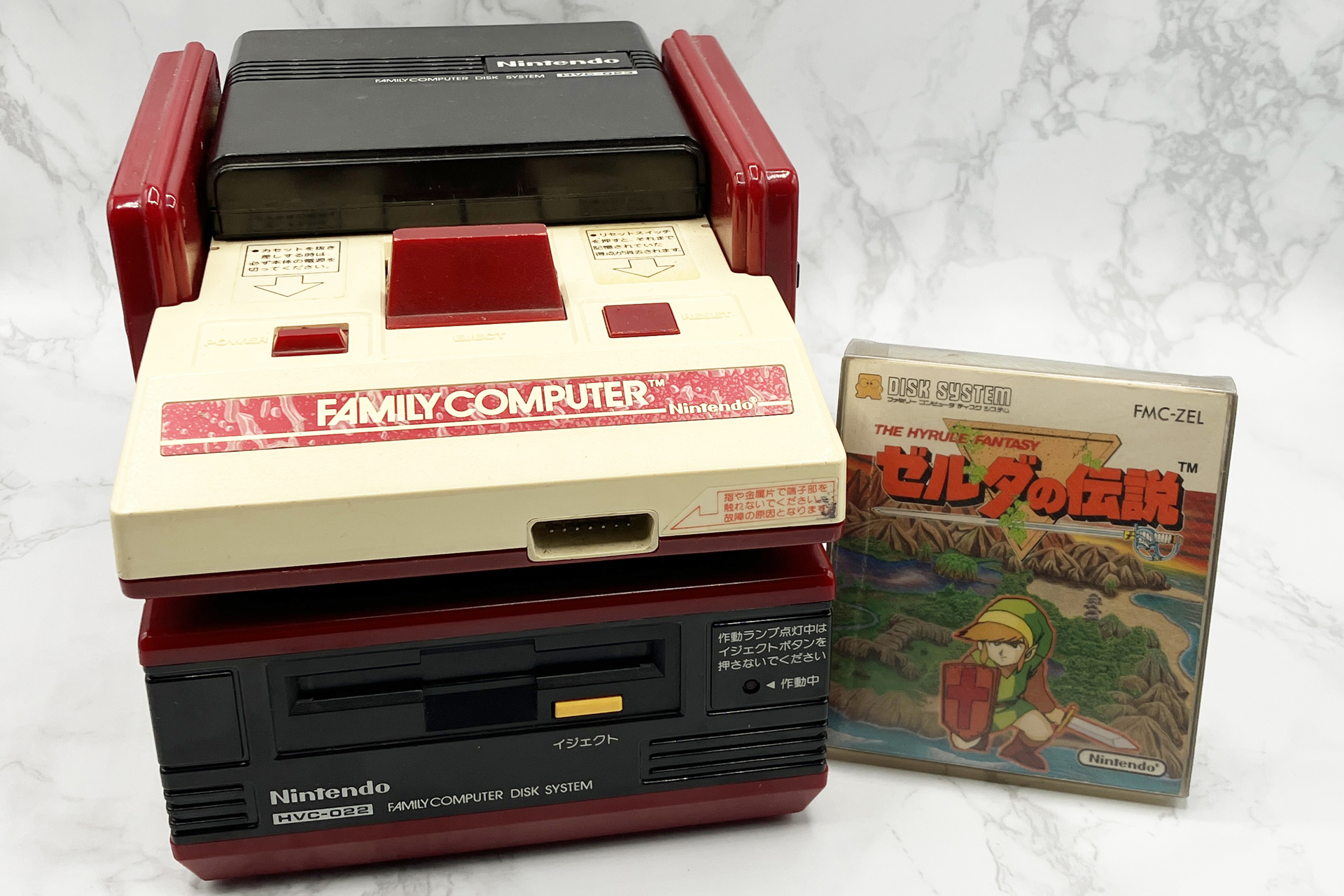 ディスクシステムと「ゼルダの伝説」のディスクカード。1986年2月21日発売。本体は15,000円（ファミコンは別売り）、ソフトは2,600円。写真は全て筆者の私物