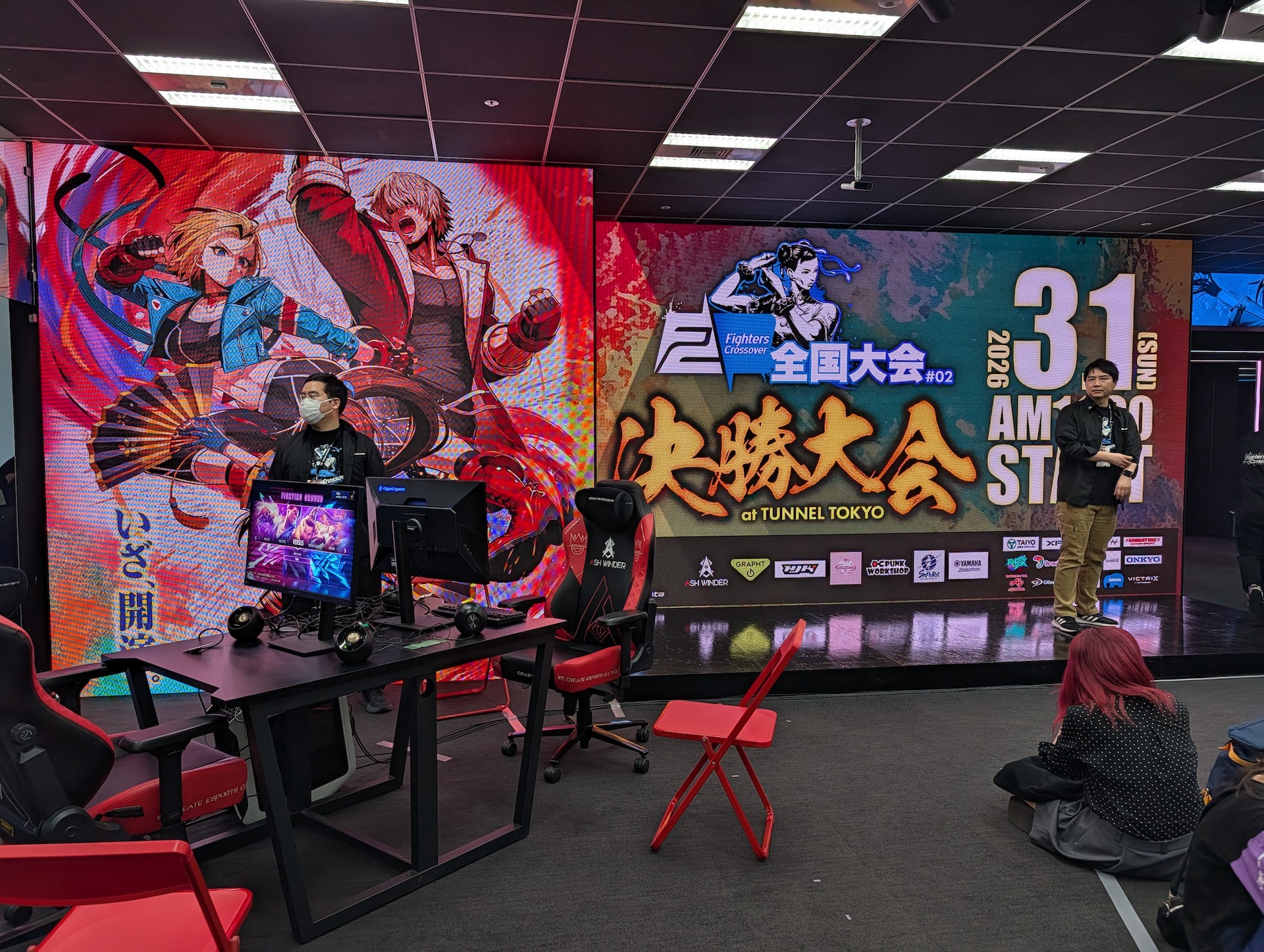 ステージのバックは全面ディスプレイ。ステージ両端に試合で使用する対戦台が設置されている