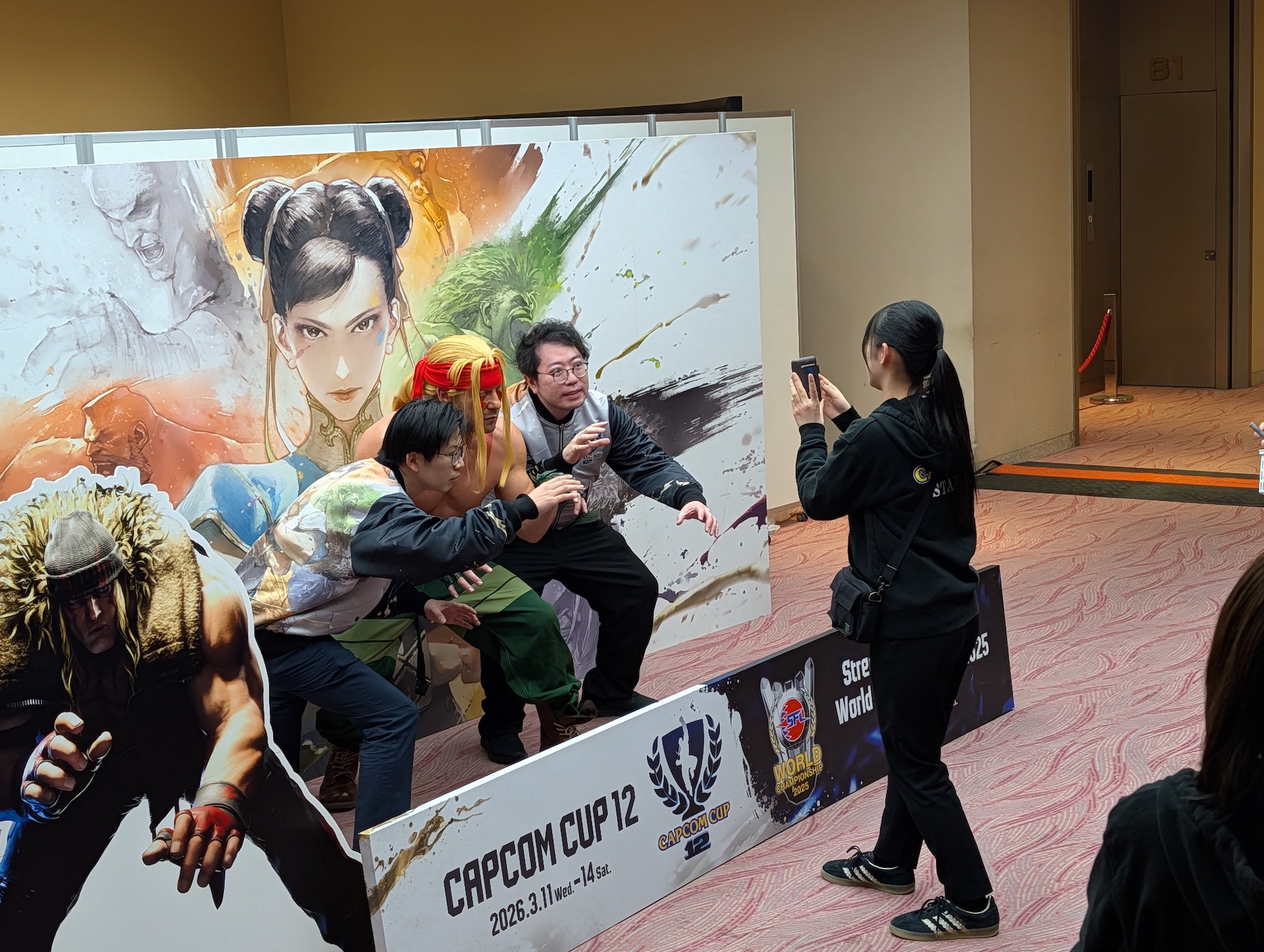 その後は撮影スペースにケニー・オメガ氏が登場！ スタッフジャンバーを着たスタッフたちと思い思いのポーズを取って写真撮影したり、サインに応じる様子などが見られた