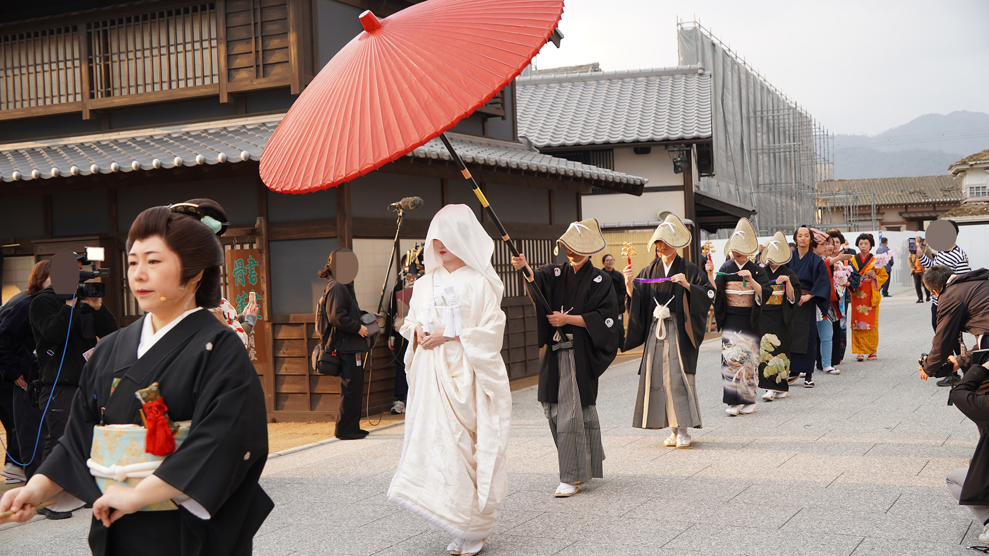 しずしずと行進する花嫁行列。綿帽子や笠で顔が見えないため、幻想的な雰囲気を醸し出している。