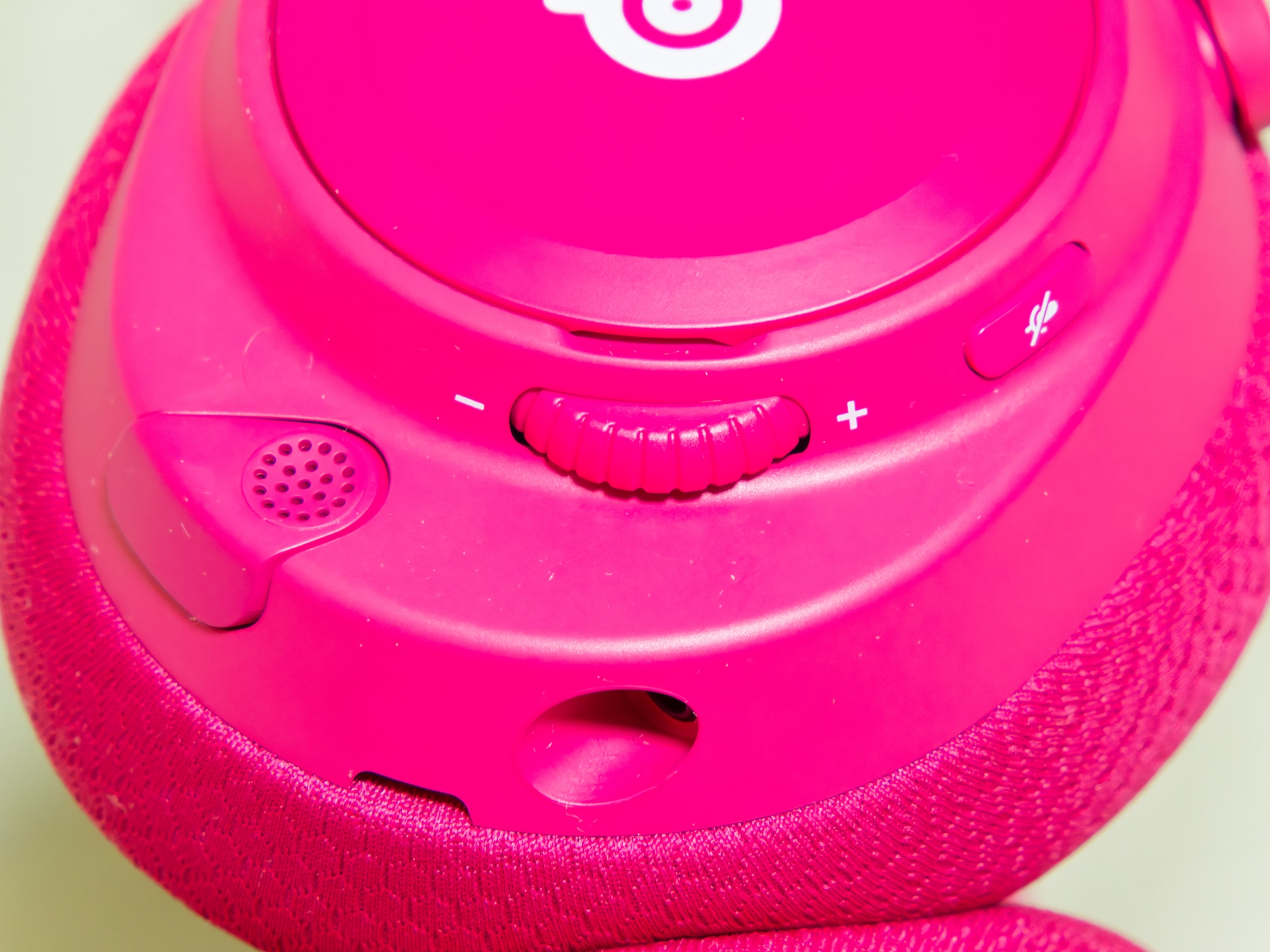 左耳部分。右からマイクミュートボタン、音量ホイール、そのしたに3.5mmワイヤオーディオジャック、さらにその左に格納式ClearCastマイクが並ぶ。このジャックに付属の5極＆4極3.5mmケーブルを接続すれば有線接続もできる。