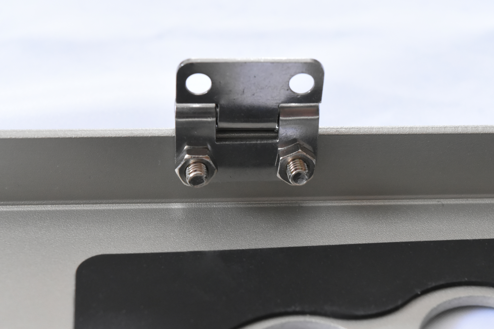 蝶番の向きはこの写真と同じ向きで取り付けよう。ナットで軽く固定したら、最後はナットをペンチで押さえながらドライバーを使って固く締めよう