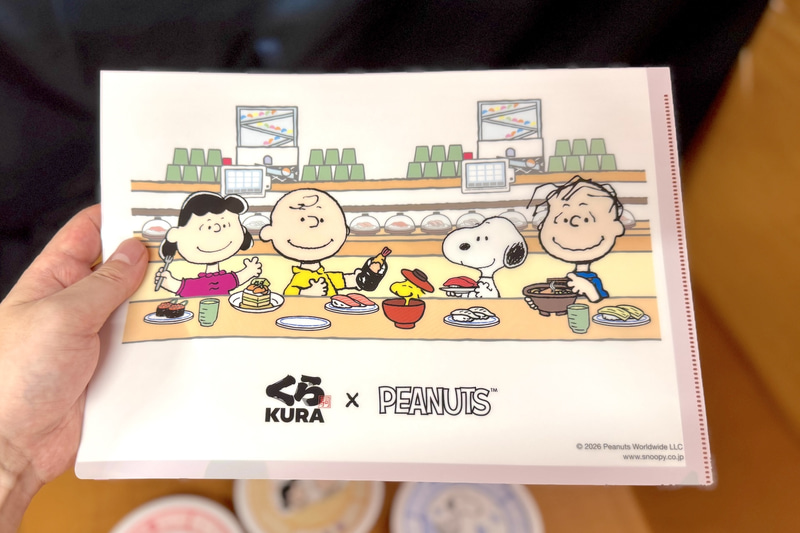 裏はスヌーピーたちがくら寿司でお寿司などを楽しむ様子が描かれた共通デザインとなっている
