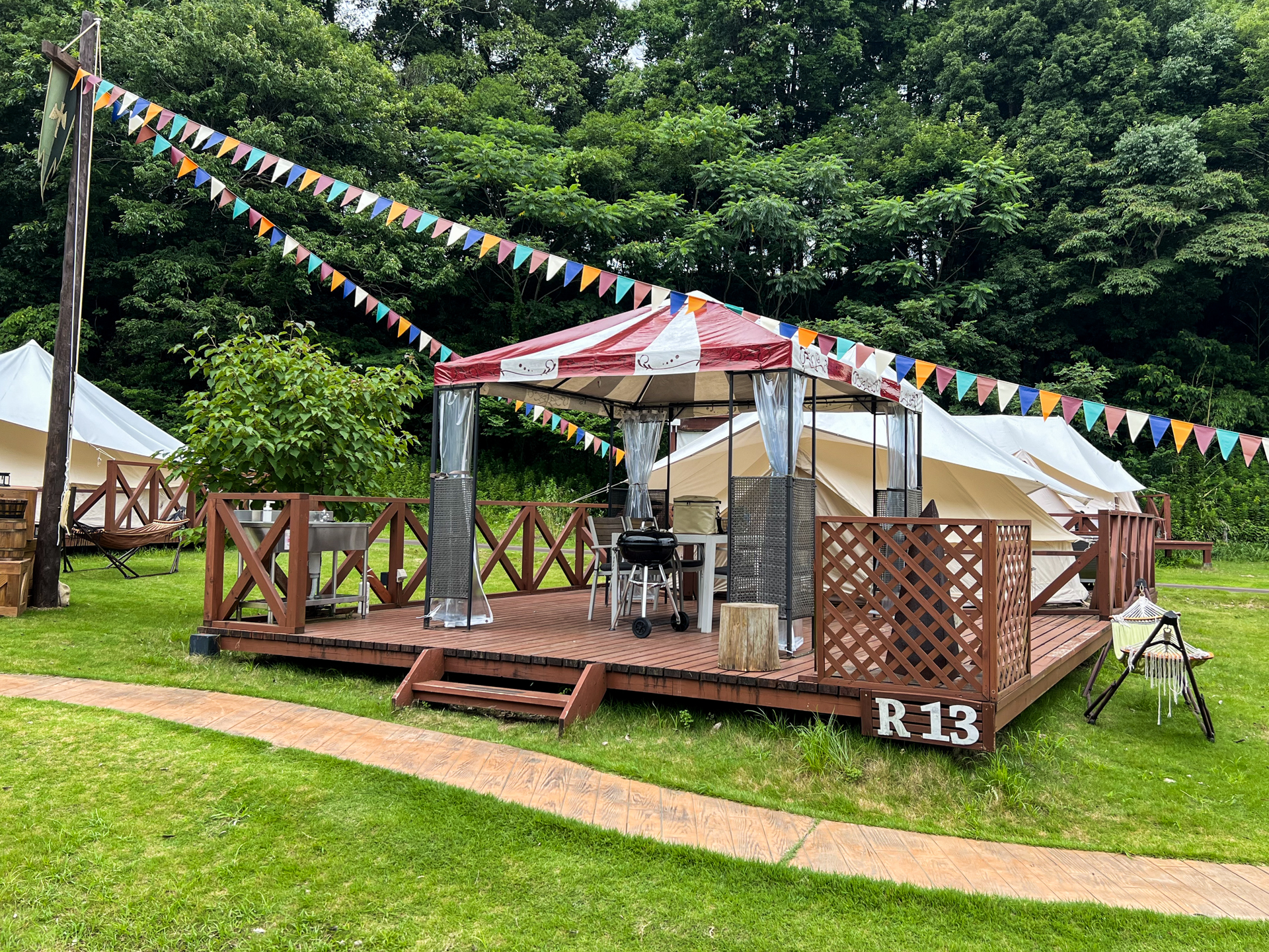 リバーサイドのテント外観。デッキにBBQセットやハンモックが備わる