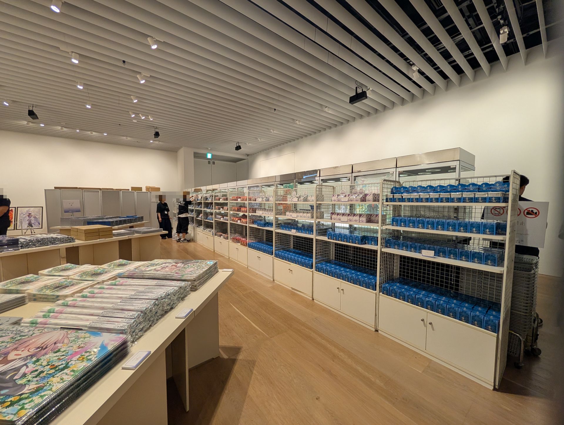 物販ブース。今回の展示会向けに描き下ろされたイラストを使用したアイテムが数多く販売されている