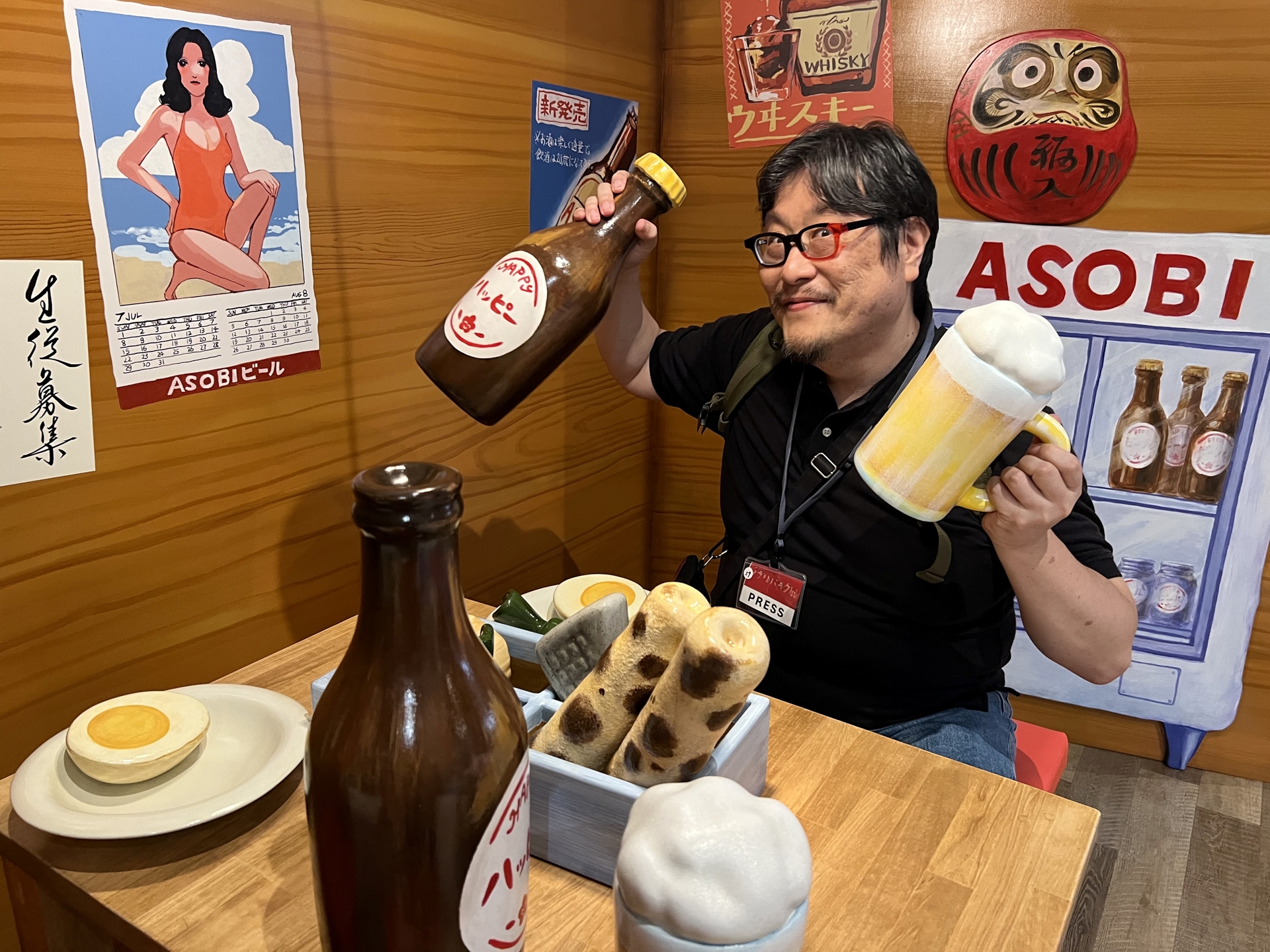 居酒屋で乾杯する僕。瓶のラベルは「ハッピービール」である