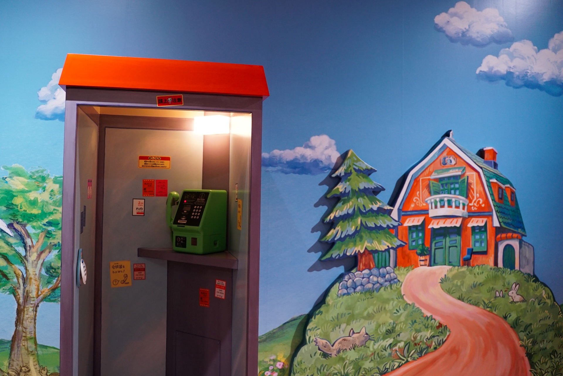 丘の上の洋館を望む電話ボックス。「受話器をとってみて！」