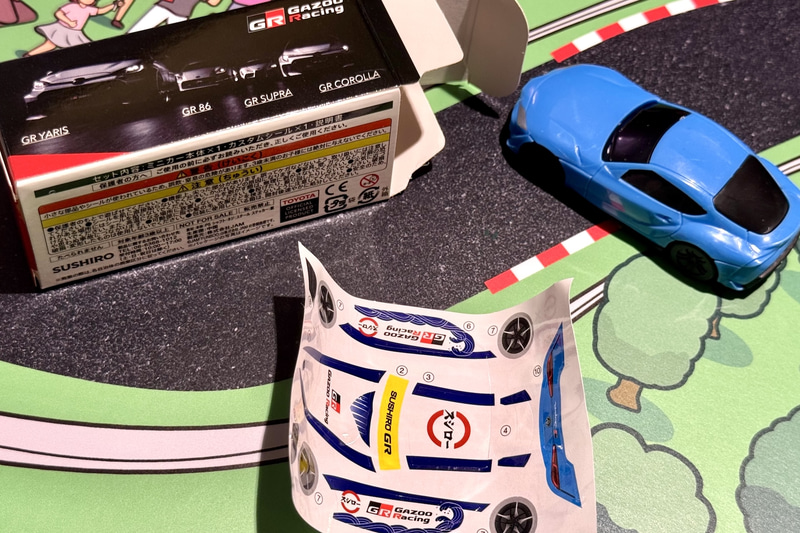 内容物としてはミニカー1台（ランダム）とデカール