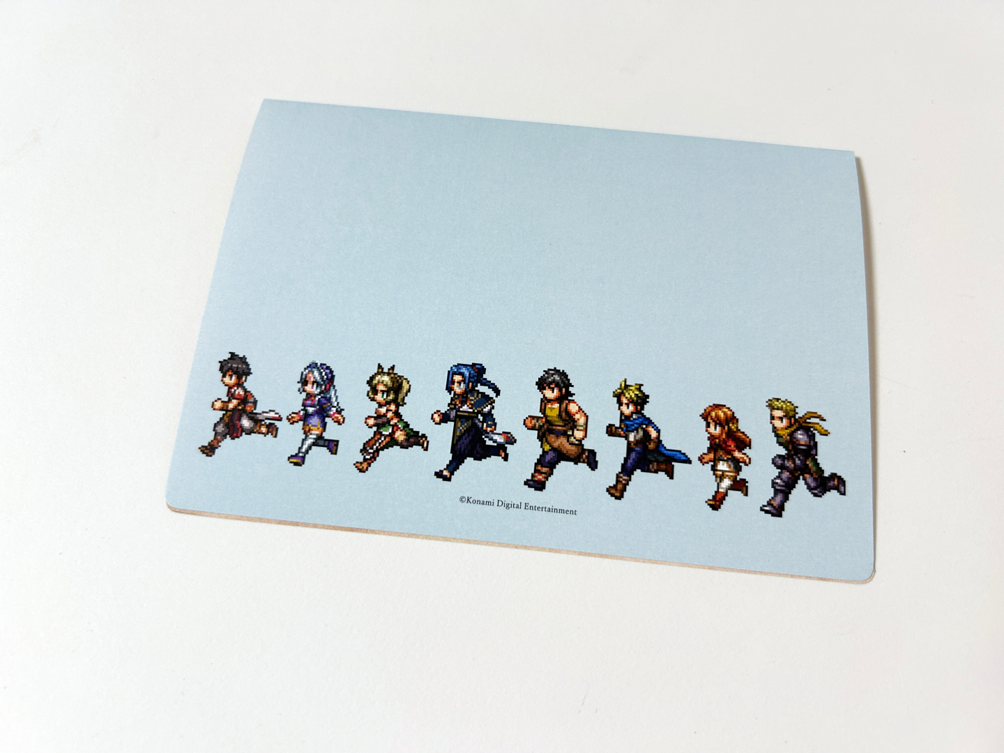 グリーティングカードも同梱。表面にはキービジュアル、裏面にはドット絵で登場キャラクターたちが描かれ、開くと制作スタッフ陣からのメッセージが書かれている
