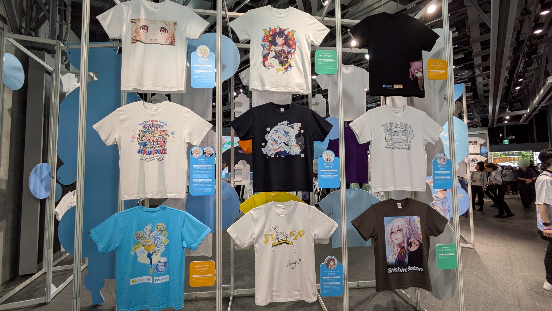 整然と並ぶ種々の「hololive Splash T-Party!」Tシャツ。デザインとコメントなど見どころが多い