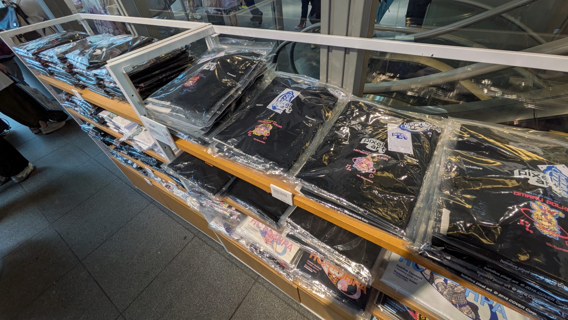 物販コーナーではKVを用いたグッズや過去に販売されたデザインTシャツ、「VTee」コラボTシャツなどが販売されている。「hololive Splash T-Party!」Tシャツは展示のみで現地販売は行なわれないため、購入はオンラインで行う必要がある