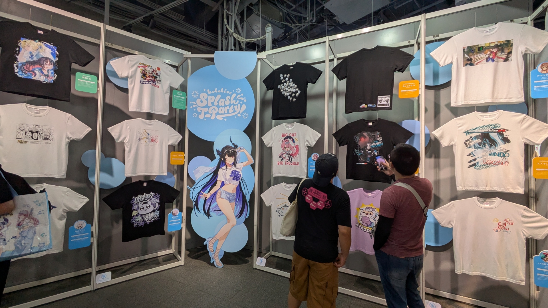整然と並ぶ種々の「hololive Splash T-Party!」Tシャツ。デザインとコメントなど見どころが多い